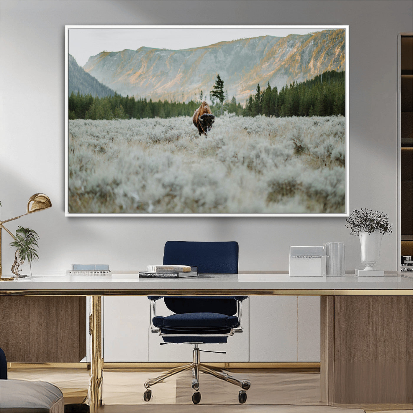 Lone bison standing in a frosted sagebrush field with a pine forest and rugged mountain range in the background under soft morning light – Wall Art Canvas Print.