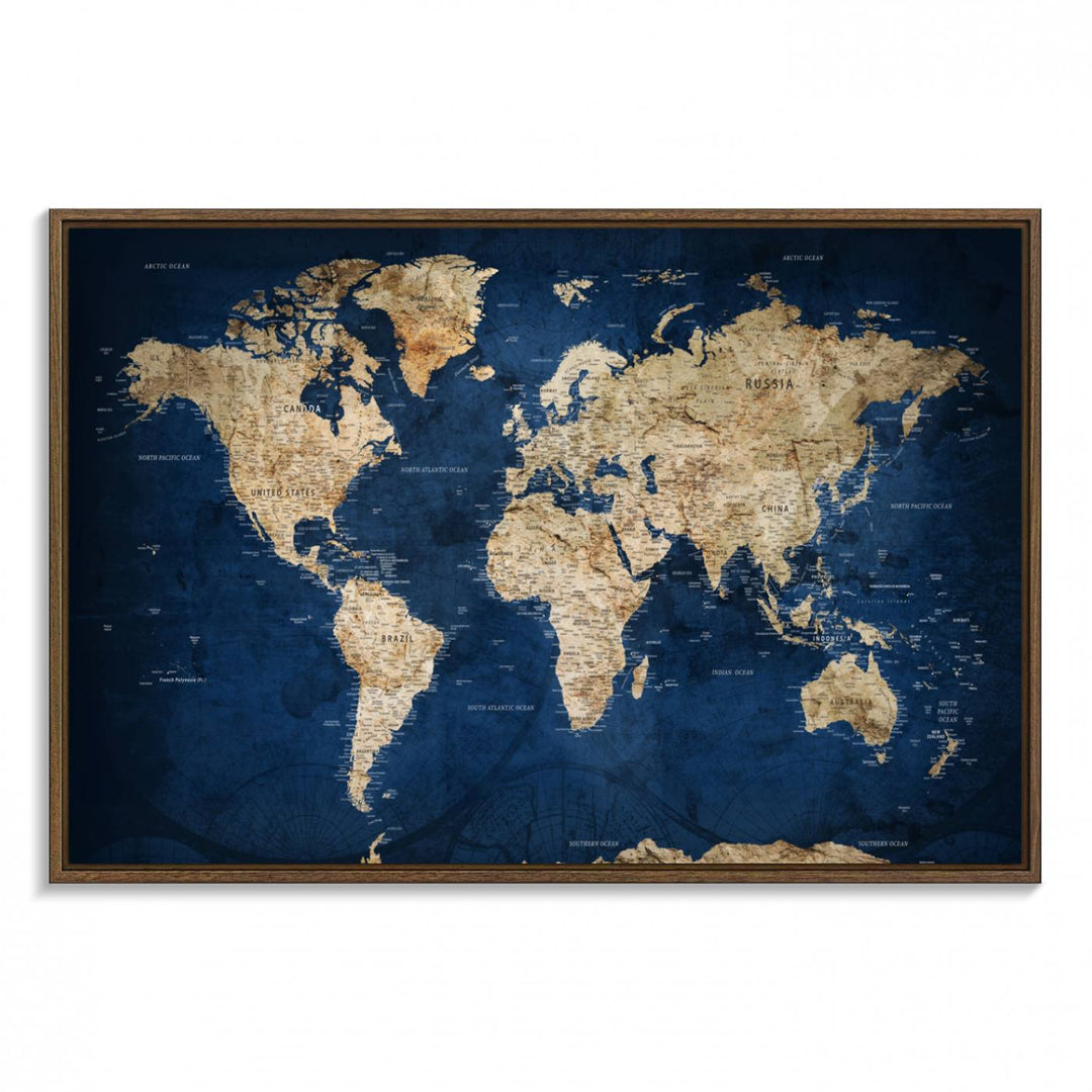 A large framed world map canvas print features beige landmasses set against a grunge-stained deep blue ocean background, creating an intriguing piece of wall art.