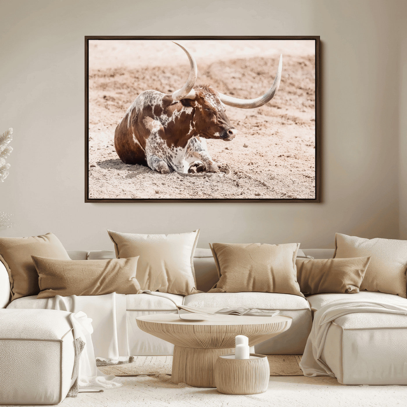 Texas Longhorn bull resting on dusty ground with warm tones, ideal for rustic western or farmhouse-themed wall decor.
