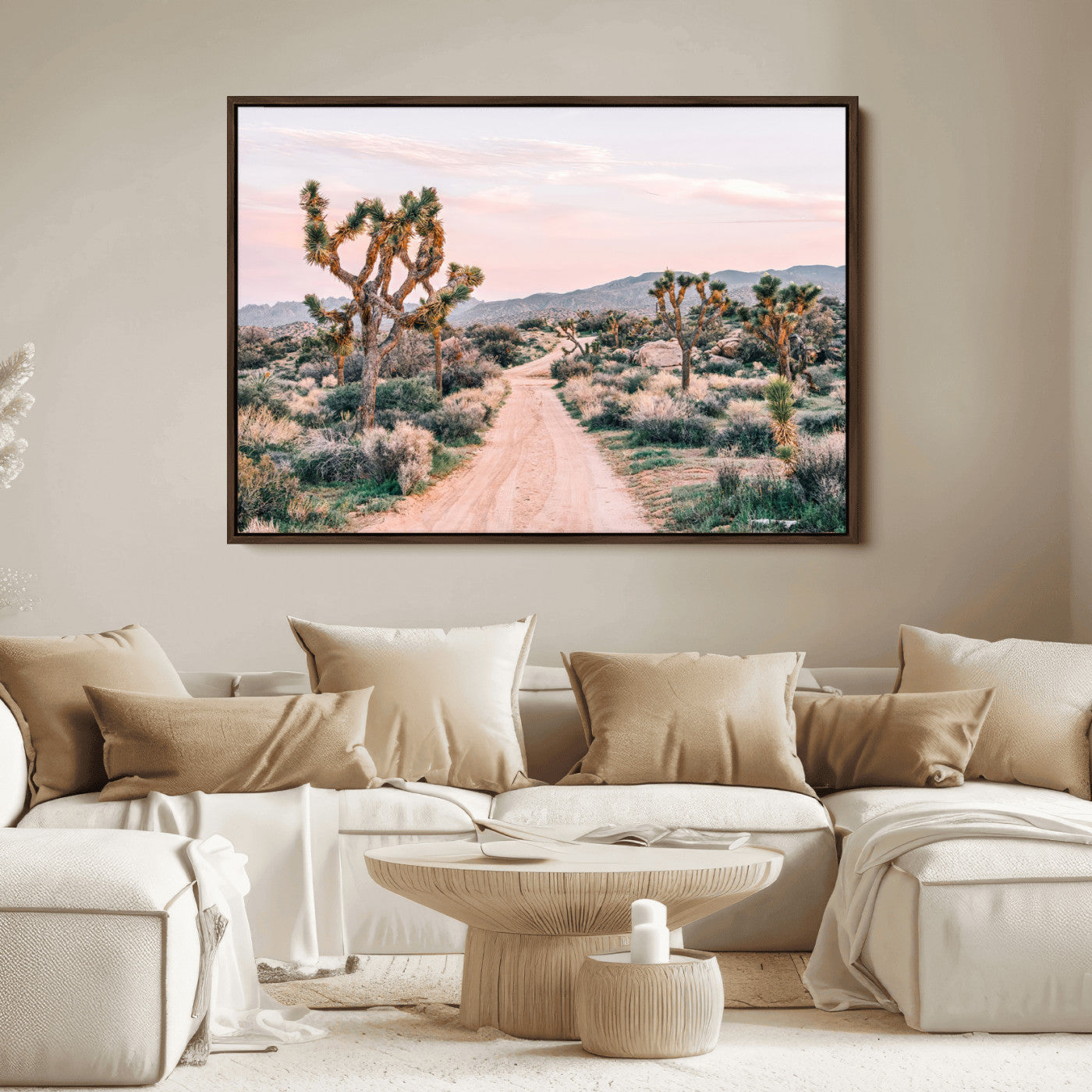 A dusty road winding through Joshua Tree National Park, framed by iconic twisted trees and warm desert tones under a soft pastel sky.
