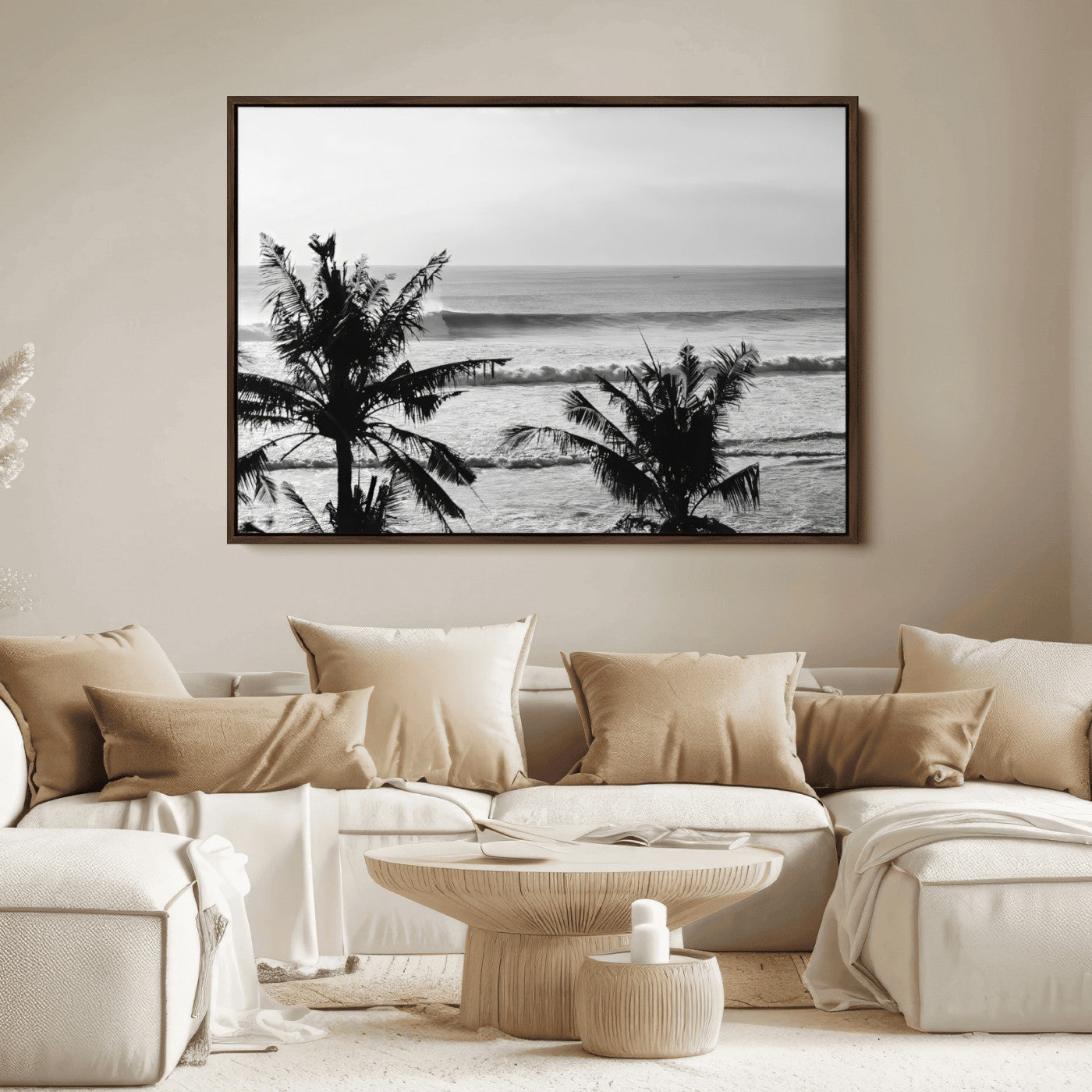 Black and white view of ocean waves crashing on a tropical coastline, framed by silhouetted palm trees under a vast, open sky.