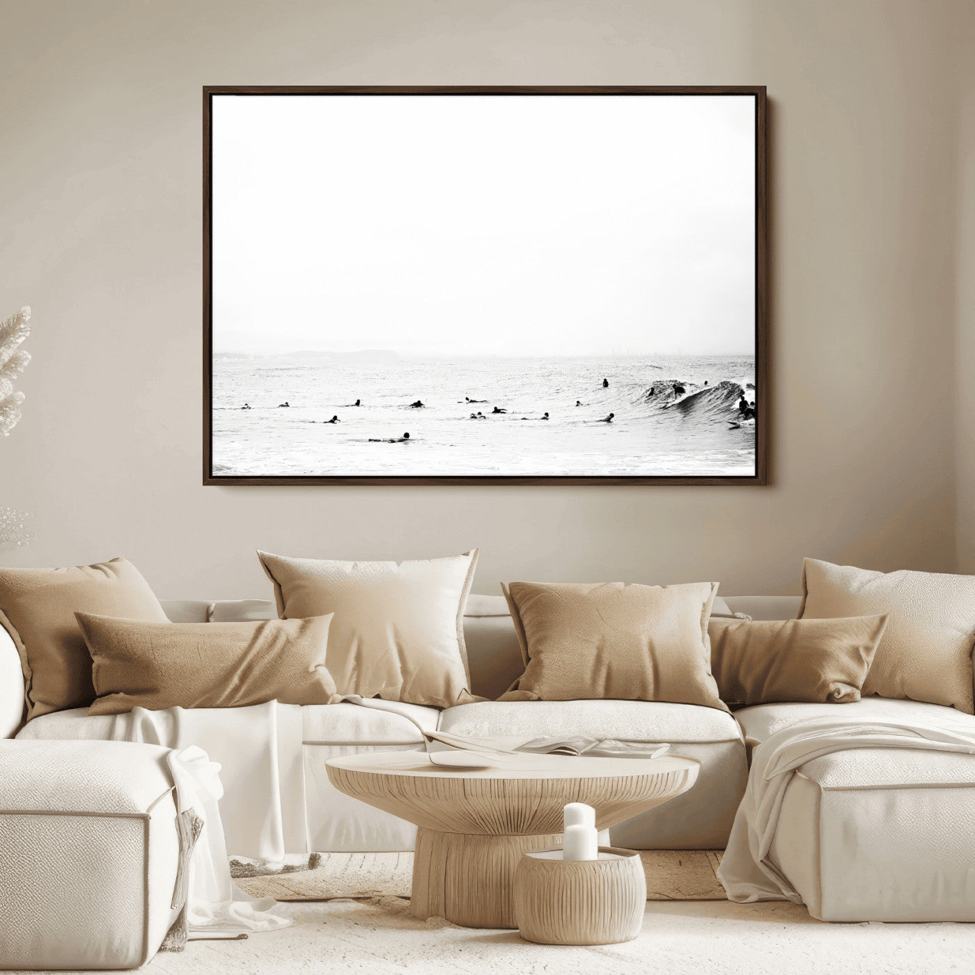 A group of surfers floating in the ocean, waiting for waves under a vast, moody sky, captured in black and white.