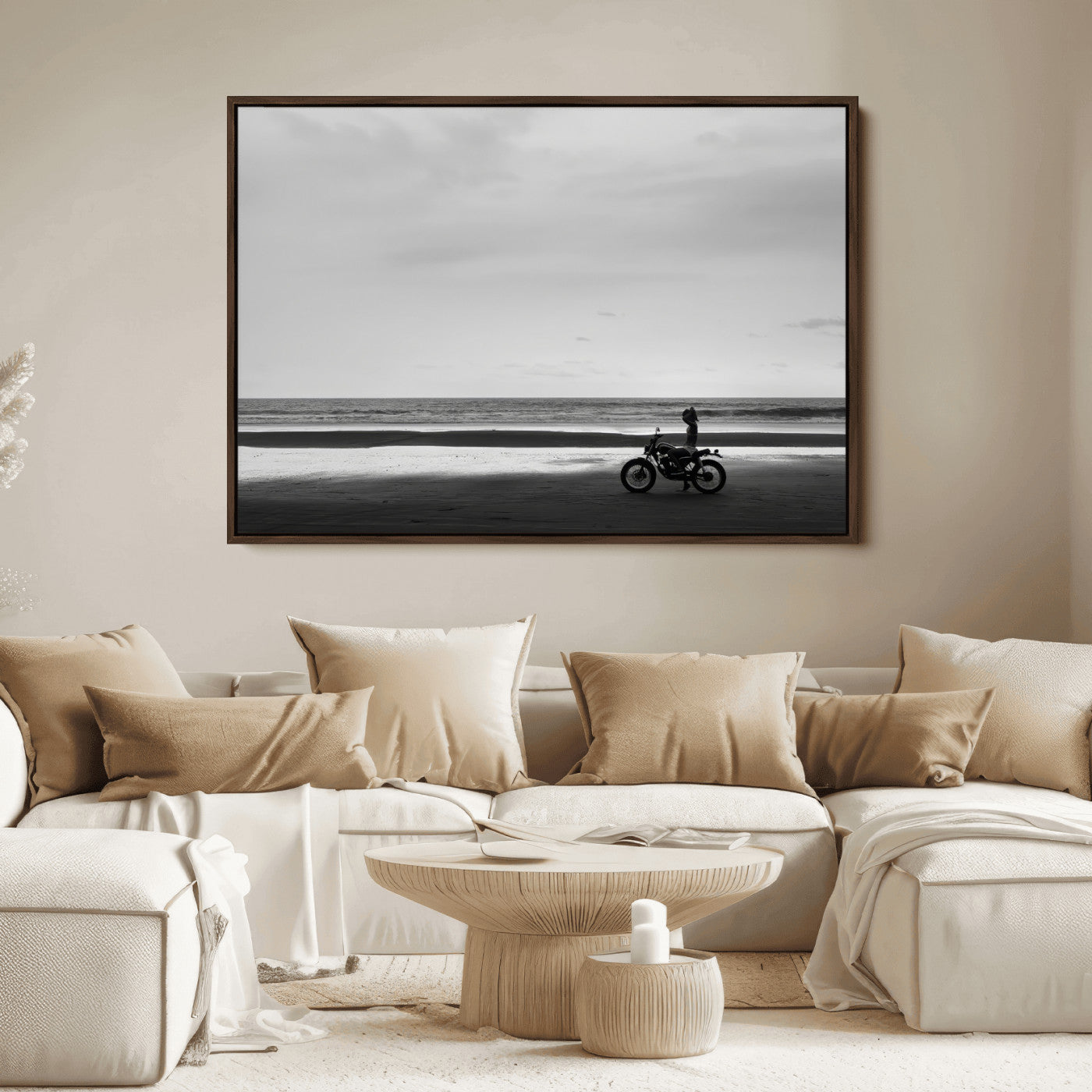 A motorcyclist on a vast beach, gazing at the ocean, capturing a moody and tranquil coastal adventure in black and white.