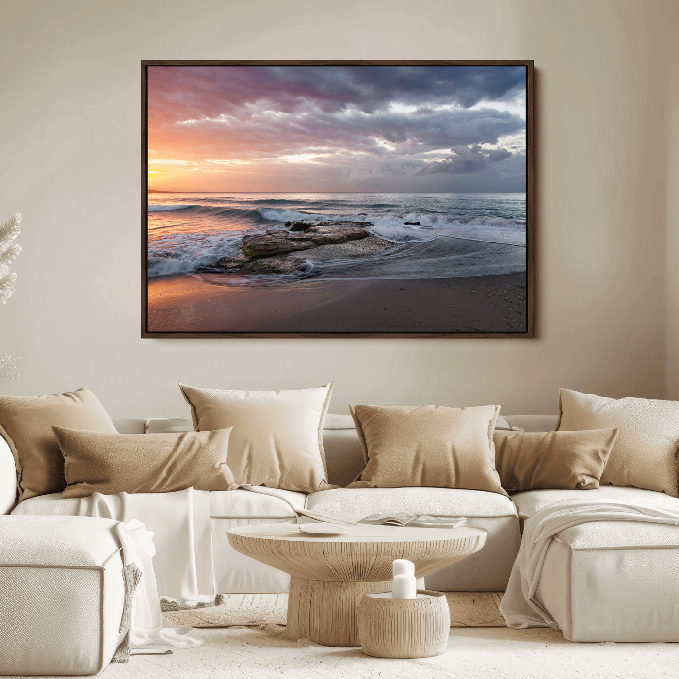 Dramatic sunset over a rocky shoreline with ocean waves gently reaching the sandy beach, creating a serene and coastal atmosphere.