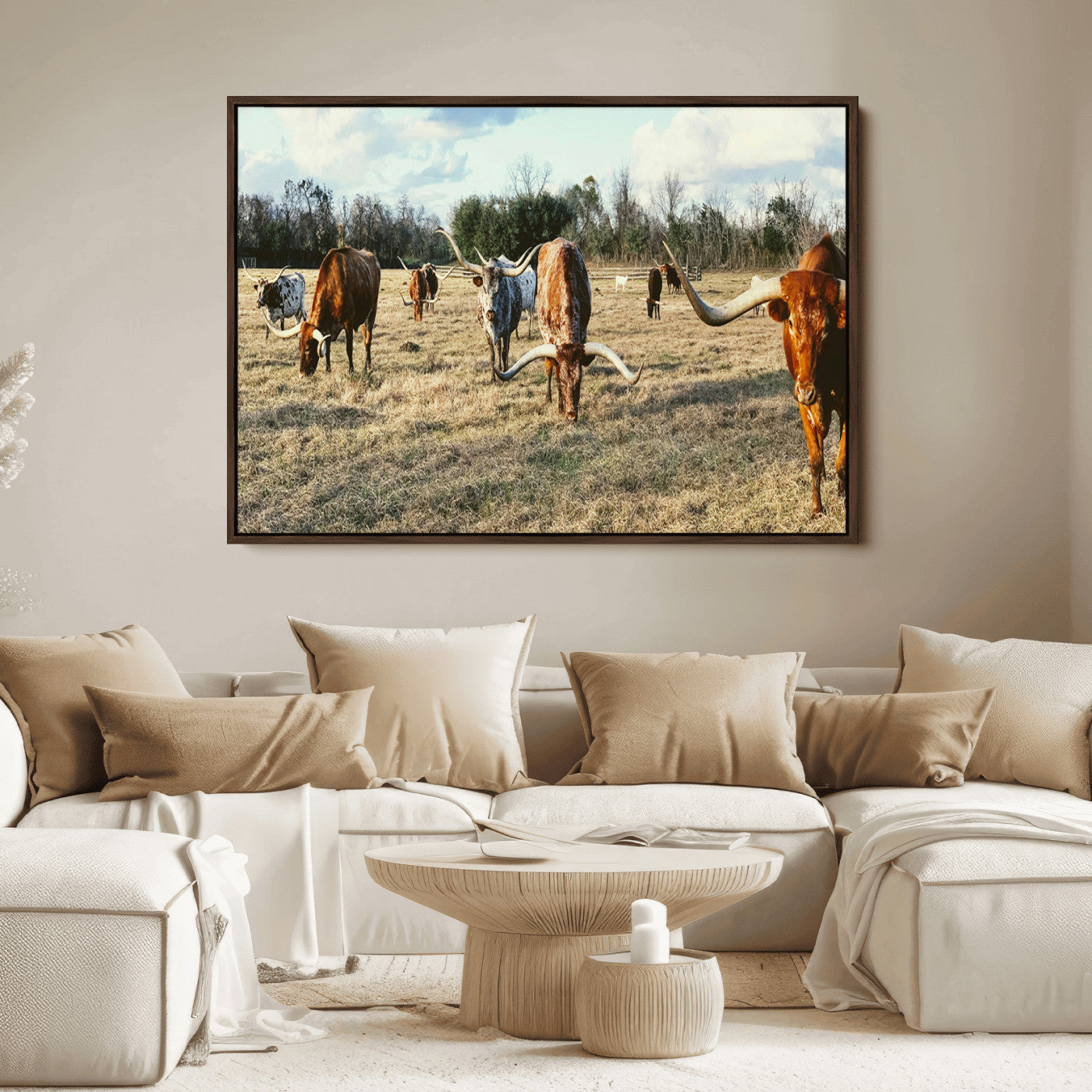 A herd of Texas Longhorn cattle grazing in an open field under a partly cloudy sky, capturing a rustic and Western ranch aesthetic.