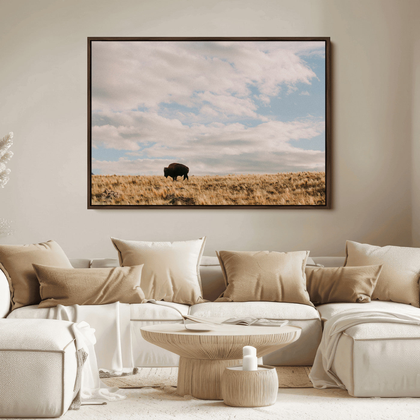 A solitary bison walking across a golden prairie under a vast, cloud-filled sky, evoking a peaceful, rustic western landscape for home decor.
