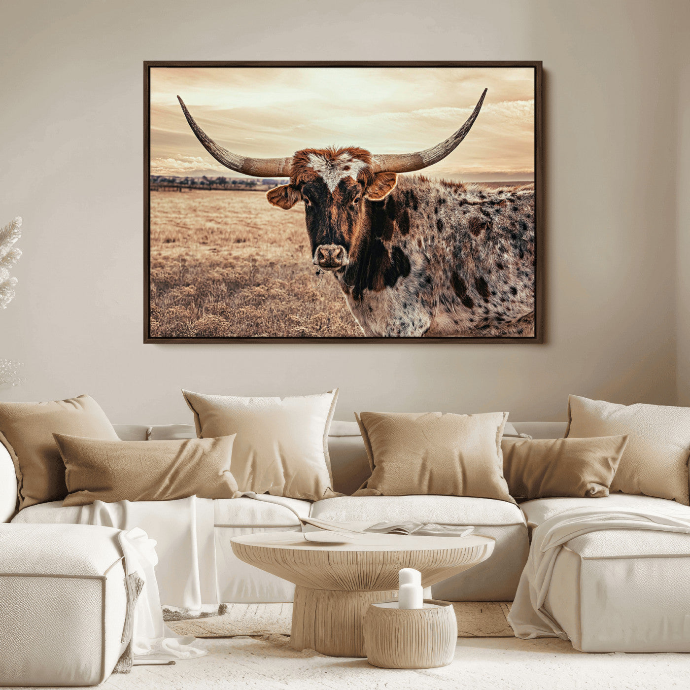 Close-up of a longhorn cow with distinctive curved horns standing in a dry grass field under a cloudy sky.