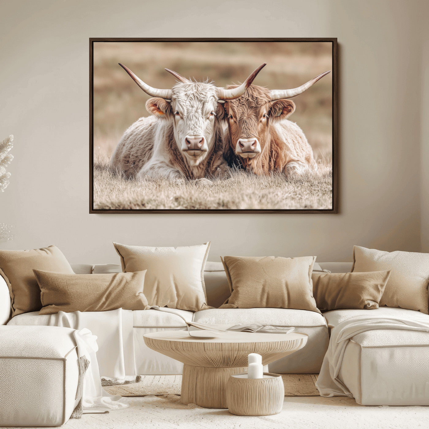Two Highland cows with long horns lying side by side on a grassy field, featuring soft natural tones and a calm rural setting.