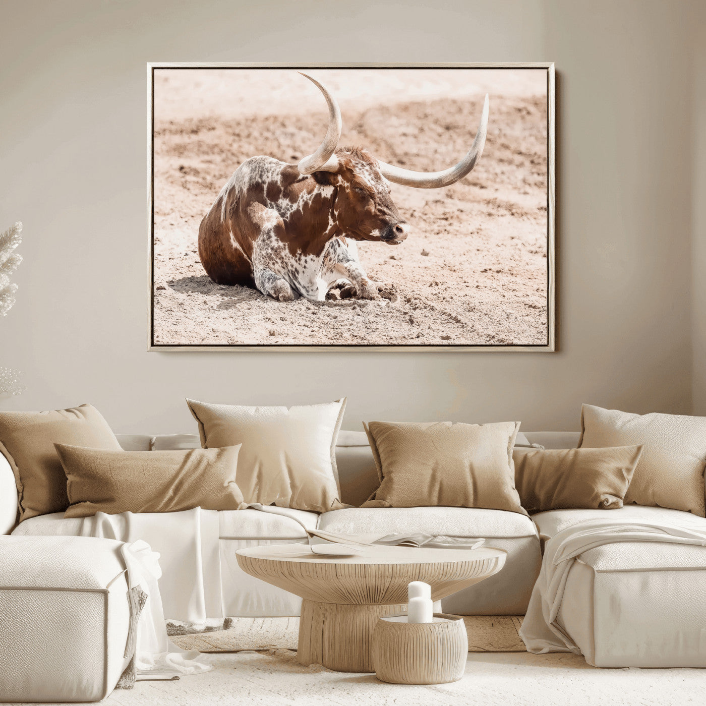 Texas Longhorn bull resting on dusty ground with warm tones, ideal for rustic western or farmhouse-themed wall decor.