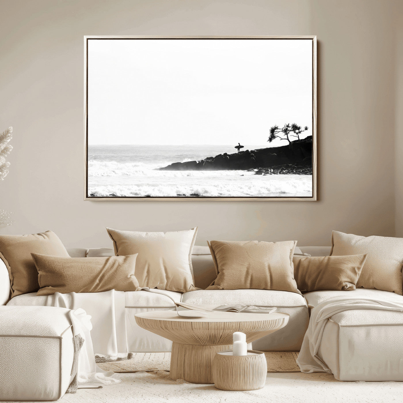 Black and white photo of a surfer standing on rocky cliffs, gazing at the waves, embodying the spirit of adventure and solitude.