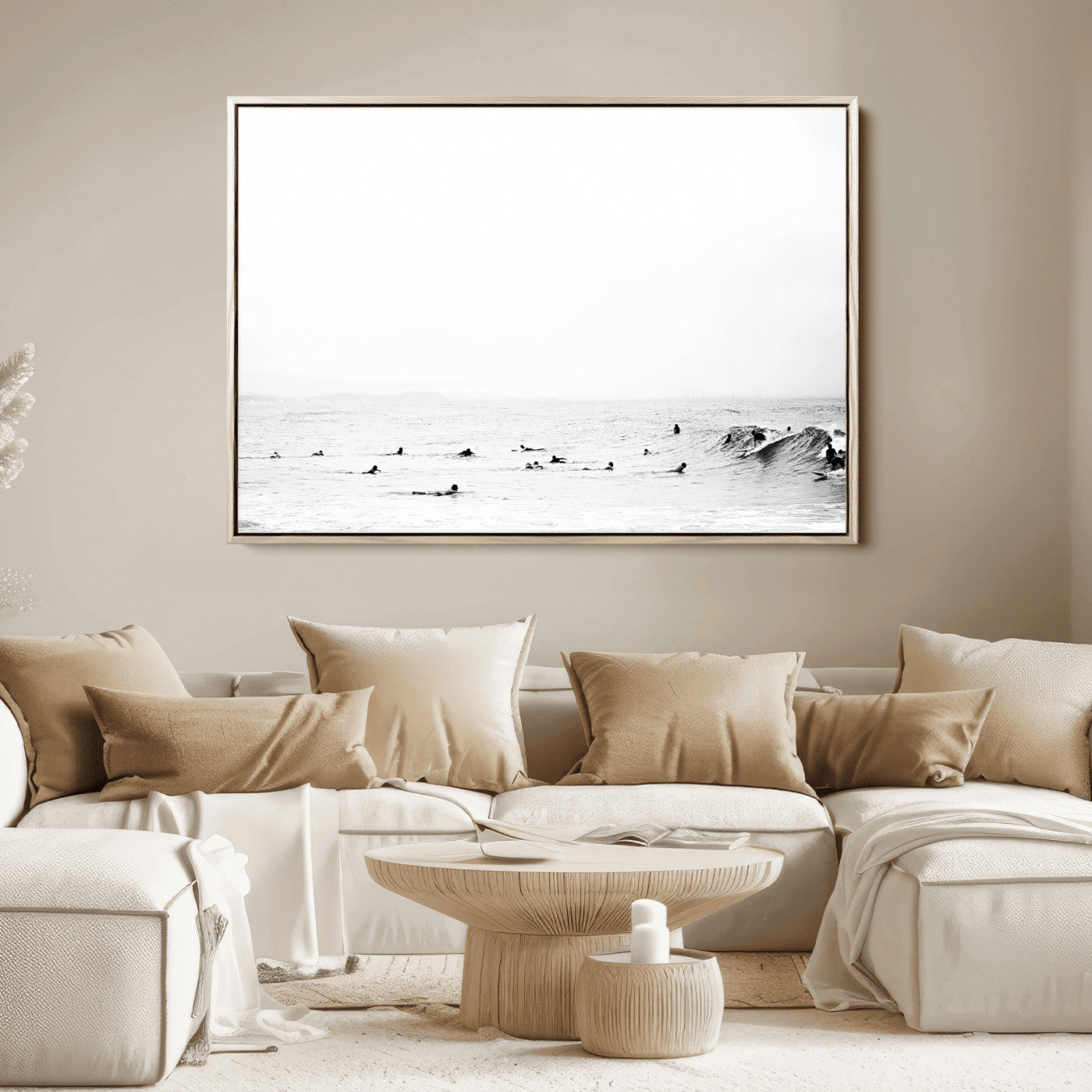 A group of surfers floating in the ocean, waiting for waves under a vast, moody sky, captured in black and white.