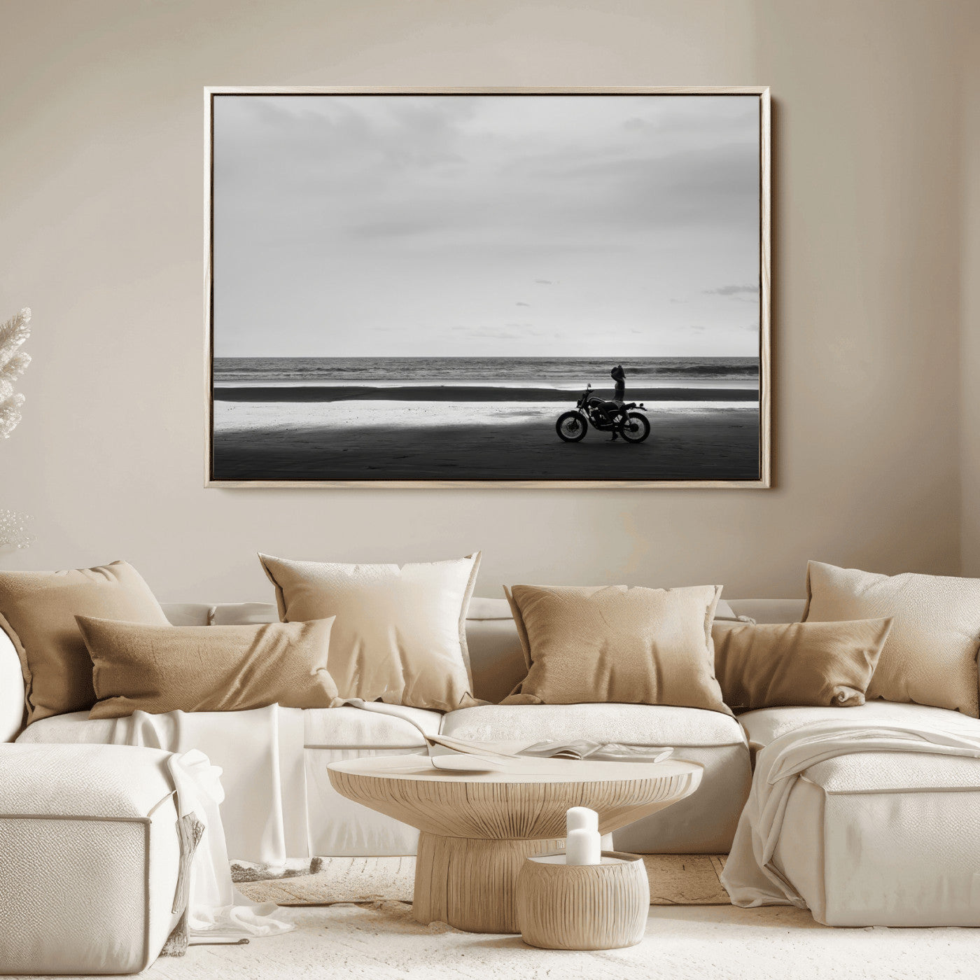 A motorcyclist on a vast beach, gazing at the ocean, capturing a moody and tranquil coastal adventure in black and white.