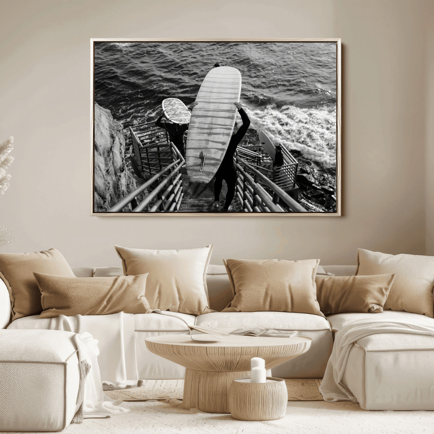 Black and white photo of surfers carrying boards down a rugged cliffside stairway, capturing a bold and adventurous coastal scene.