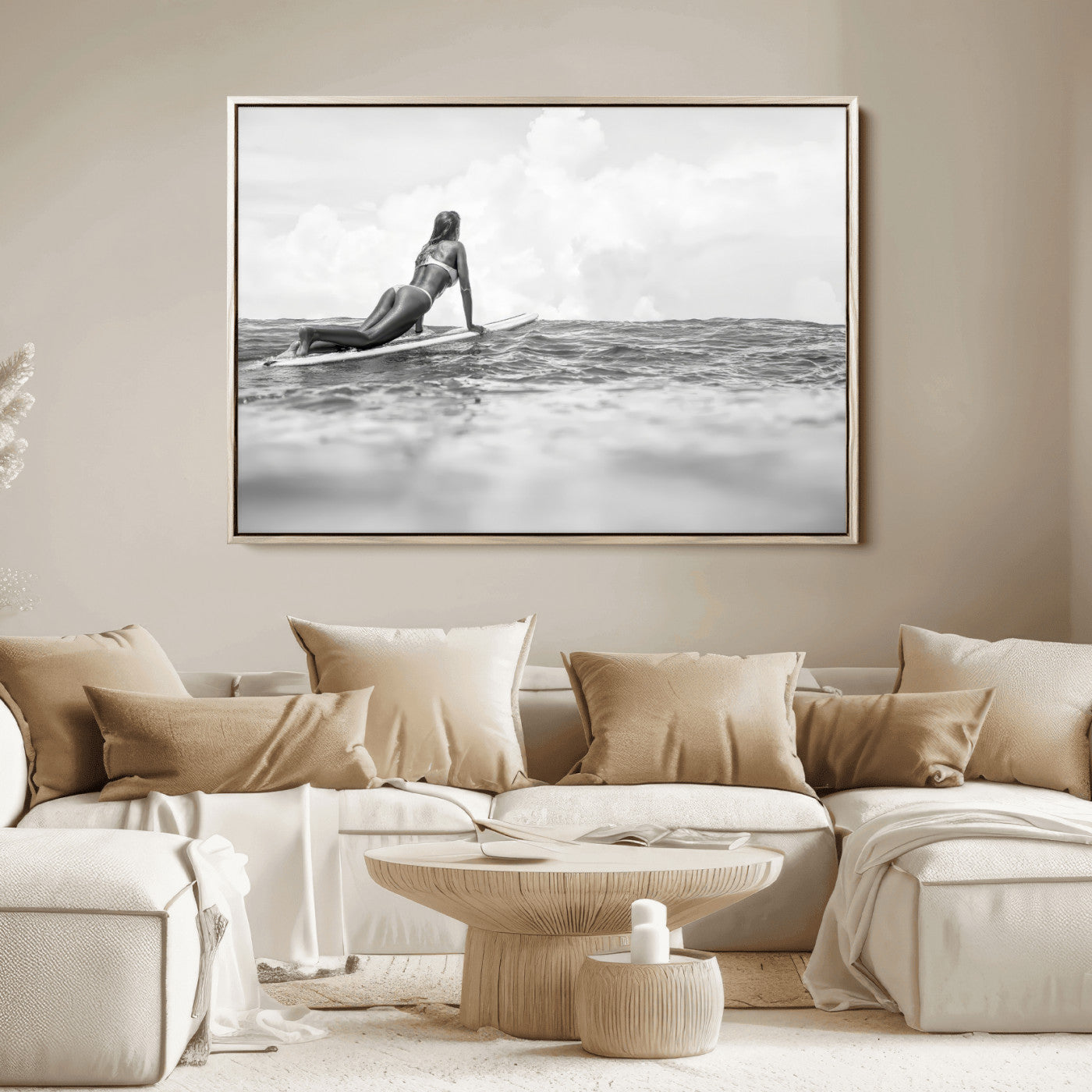 A black and white ocean scene featuring a surfer girl waiting on her board, gazing at the horizon, capturing a tranquil and adventurous coastal moment.