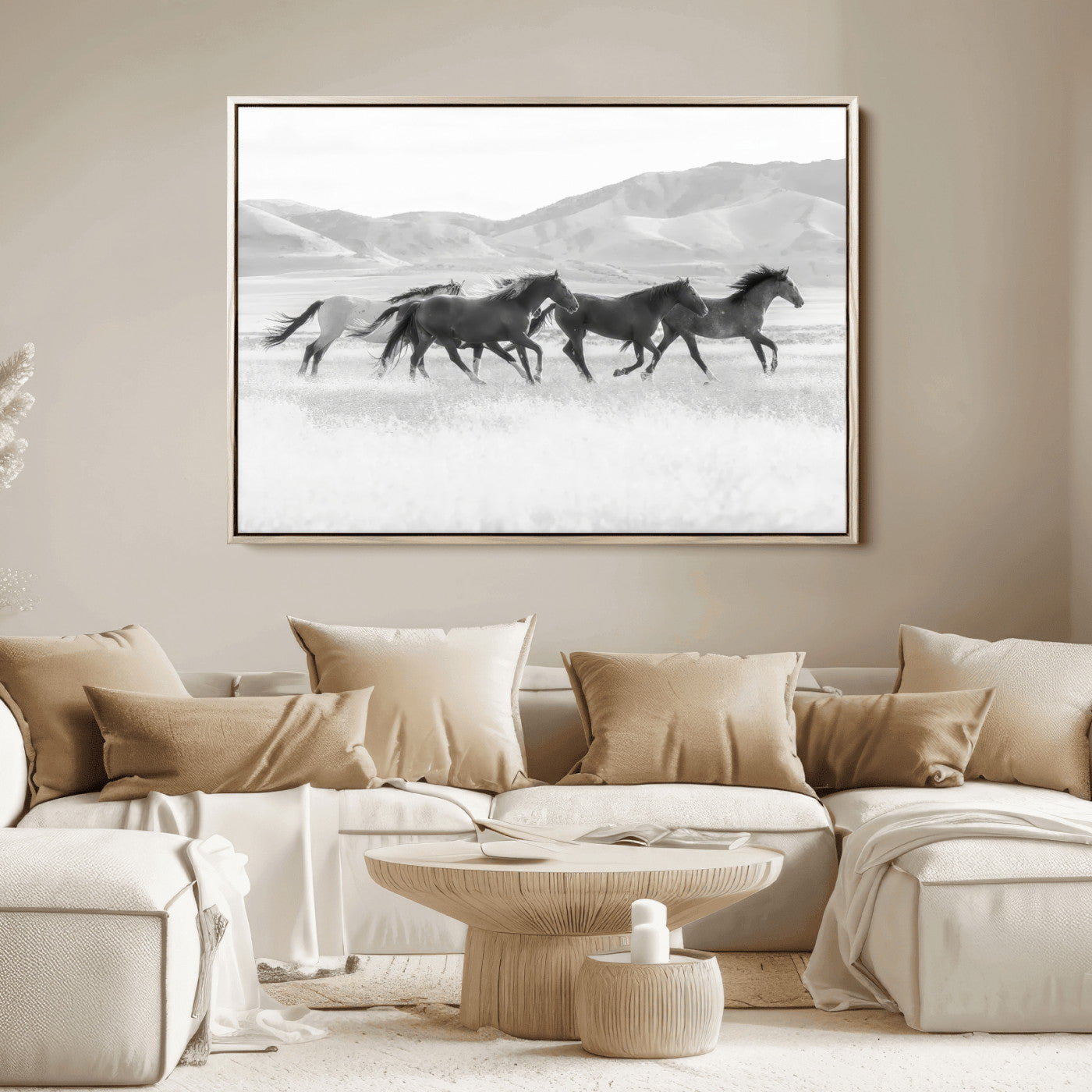 A black and white image of wild horses running freely across an open grassland, capturing the power and beauty of untamed nature in a rustic western setting.