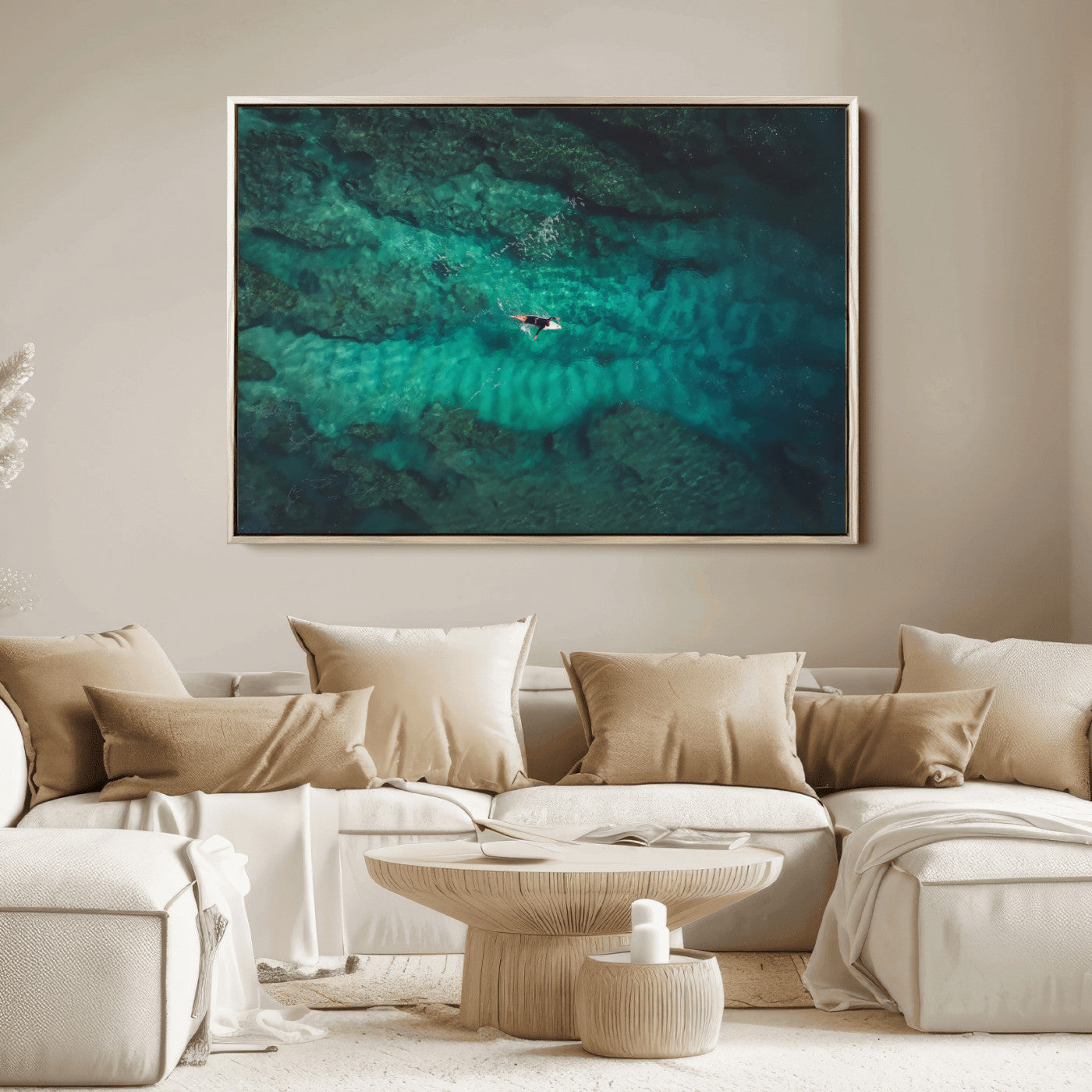 An aerial view of a solo surfer paddling through crystal-clear turquoise waters over a sunlit reef, capturing the beauty and serenity of open water surfing.
