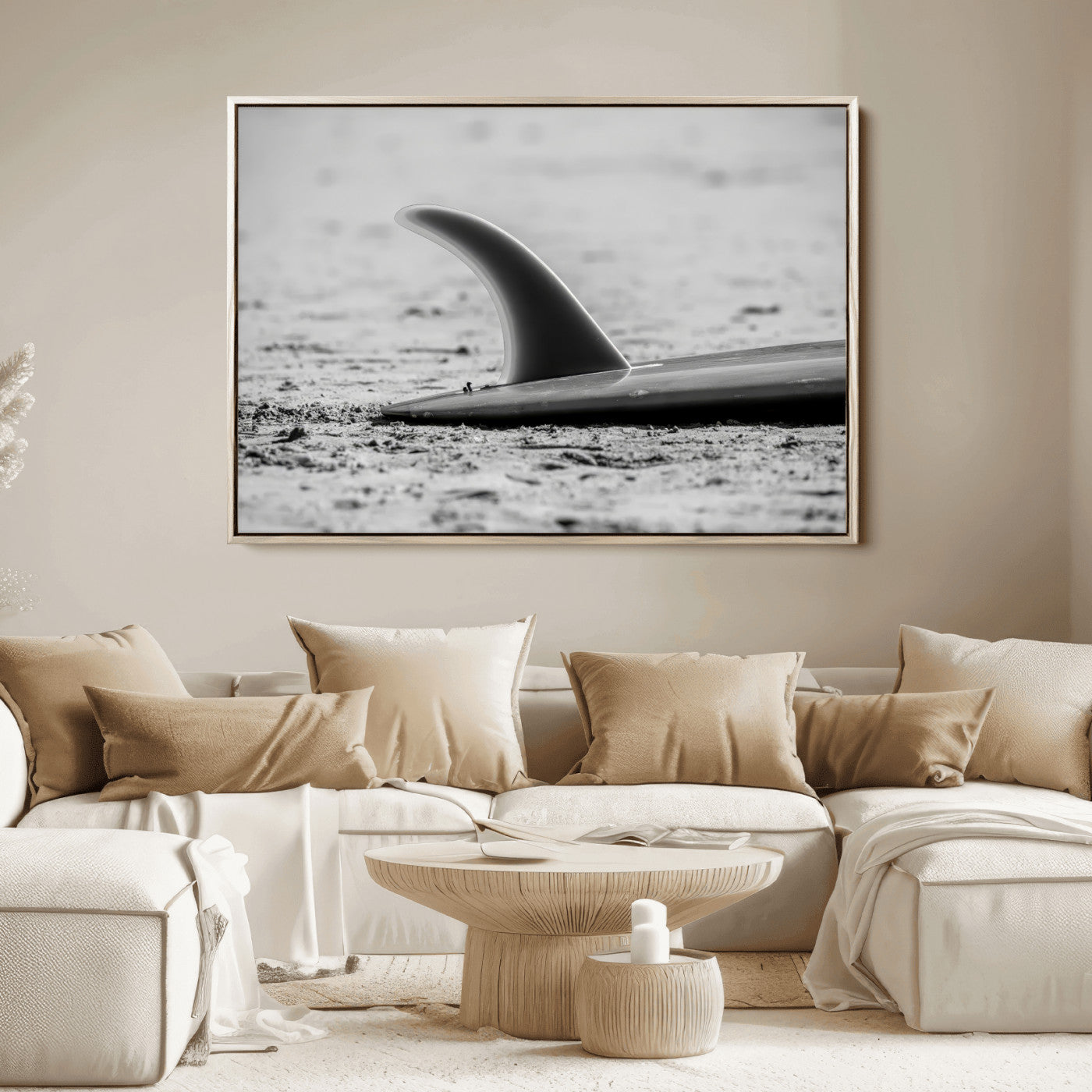 A black and white close-up of a surfboard fin resting on the sandy shore, highlighting minimalist beach aesthetics and classic surf culture.