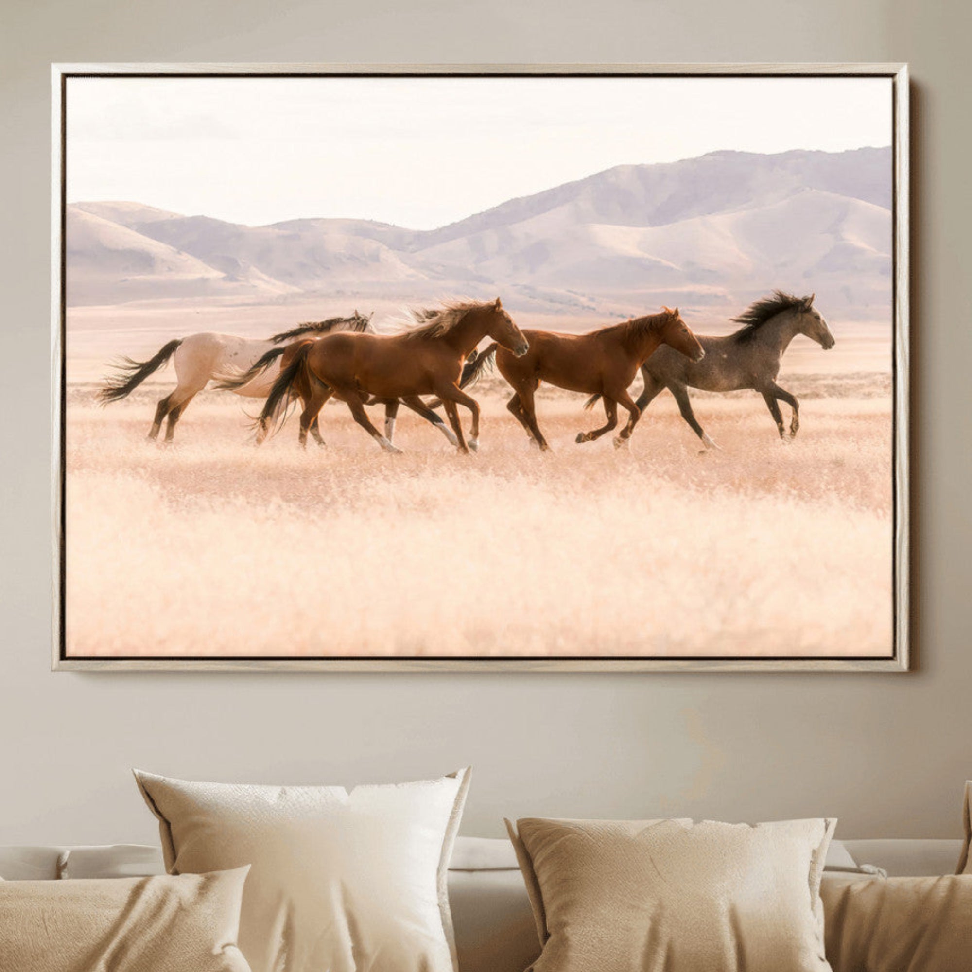 A herd of wild horses galloping through a sunlit desert plain with mountains in the background, perfect for rustic or western-themed wall decor.