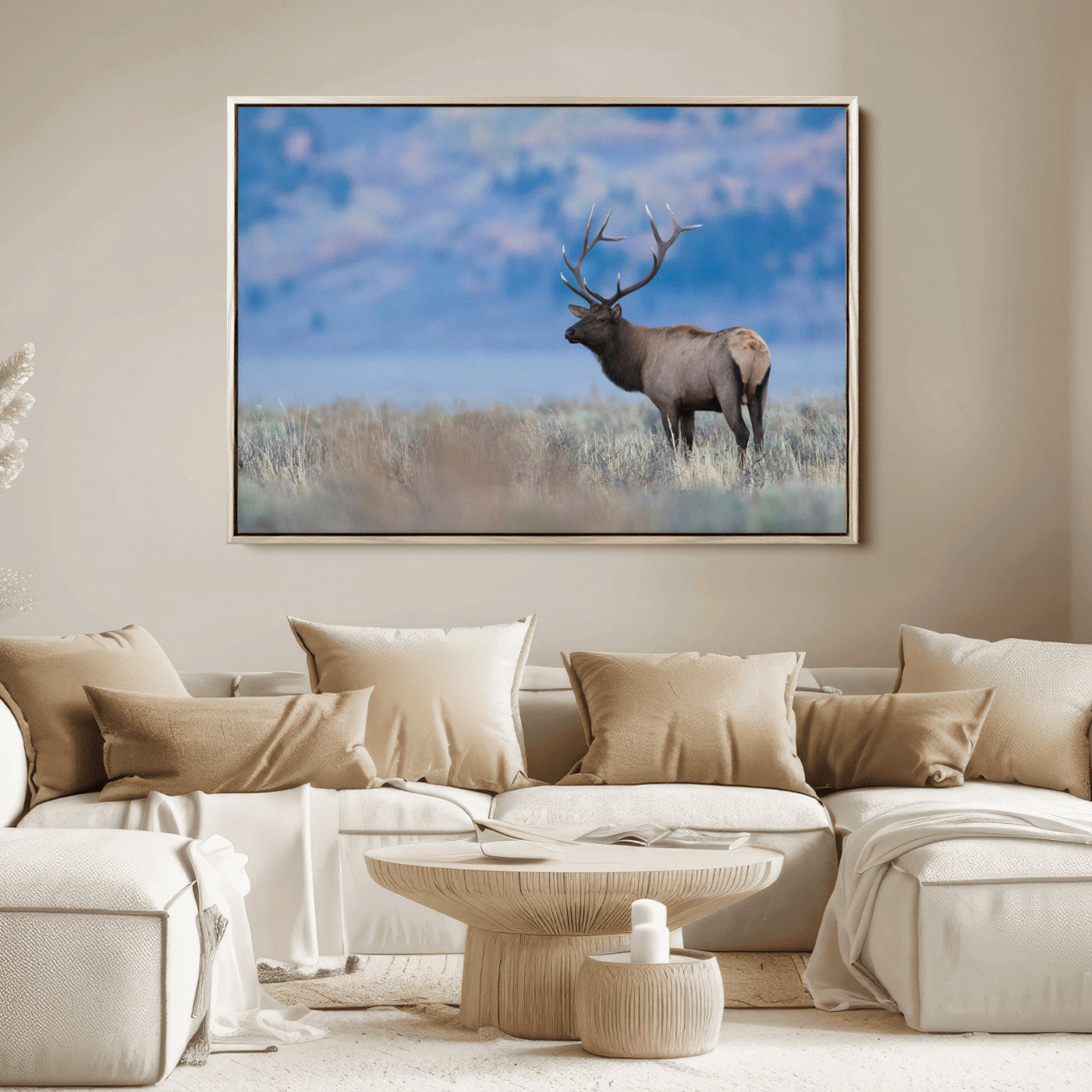 Elk with large antlers standing in open field, mountains blurred in background, perfect for rustic cabin or lodge-style decor.
