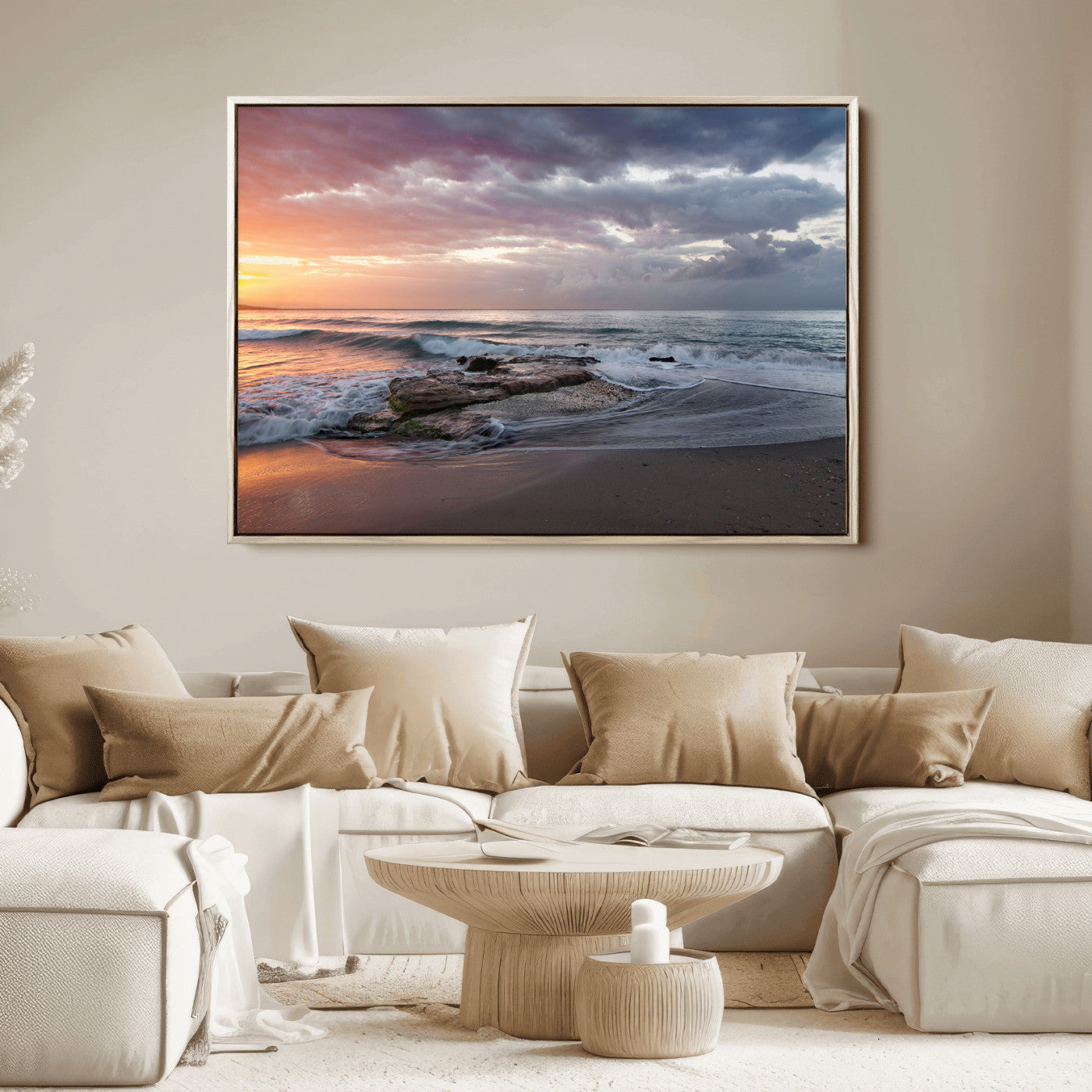 Dramatic sunset over a rocky shoreline with ocean waves gently reaching the sandy beach, creating a serene and coastal atmosphere.