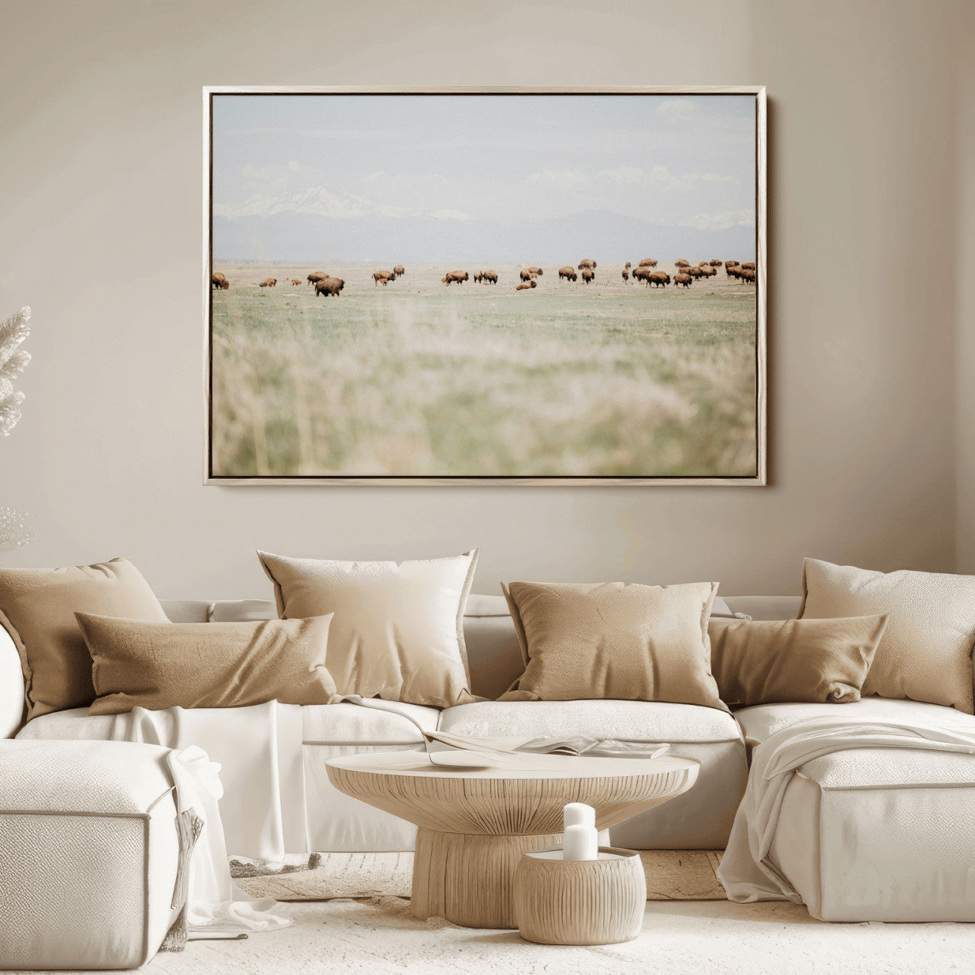 A herd of bison grazing in an open prairie with distant mountains under a soft sky, creating a serene and rustic Western landscape.