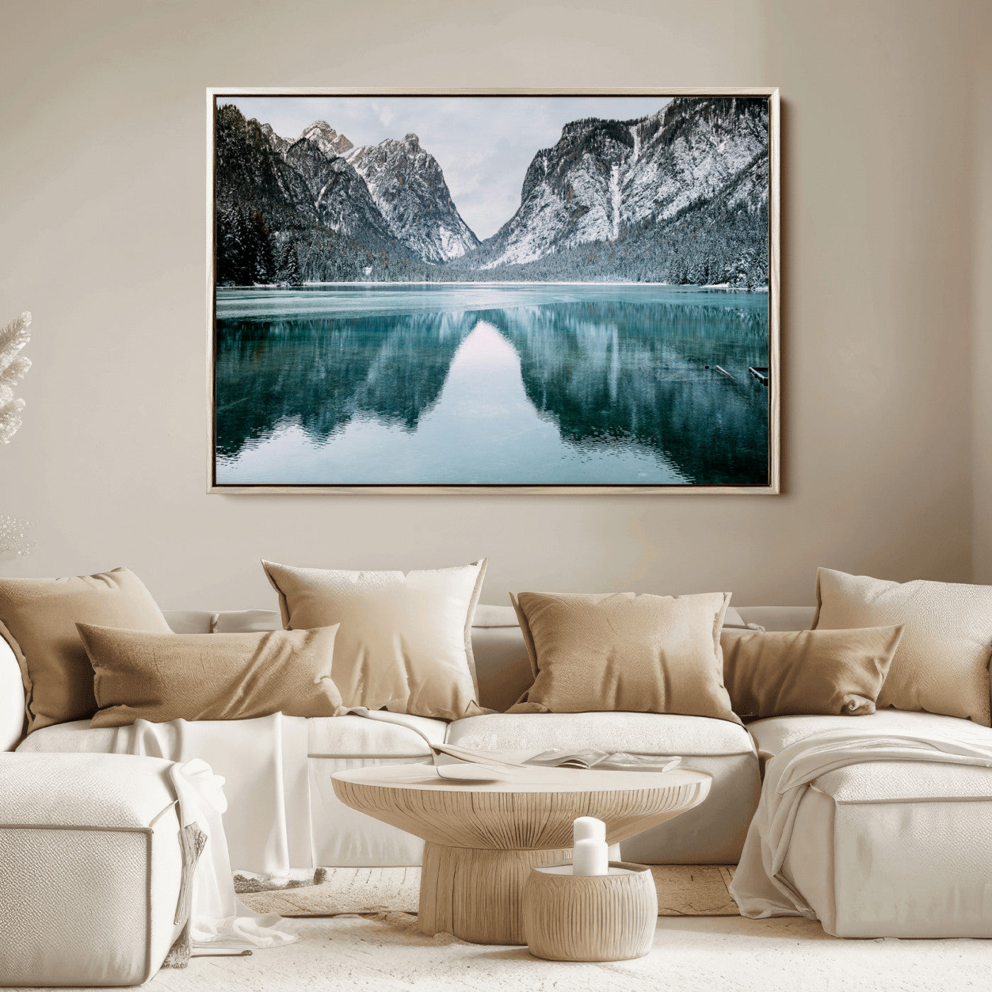 Crystal-clear alpine lake reflecting snow-covered mountains, surrounded by evergreen trees, creating a serene and tranquil winter landscape.