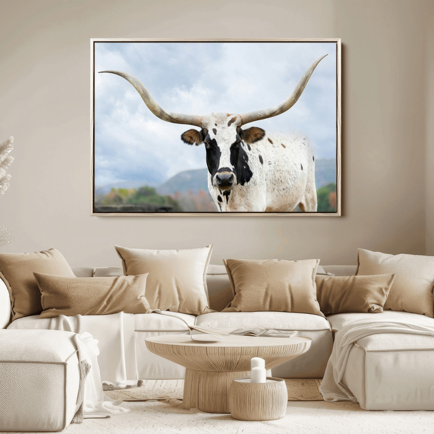 Close-up of a Texas Longhorn with curved horns, black and white markings, set against a cloudy sky and distant hills, perfect for rustic decor.