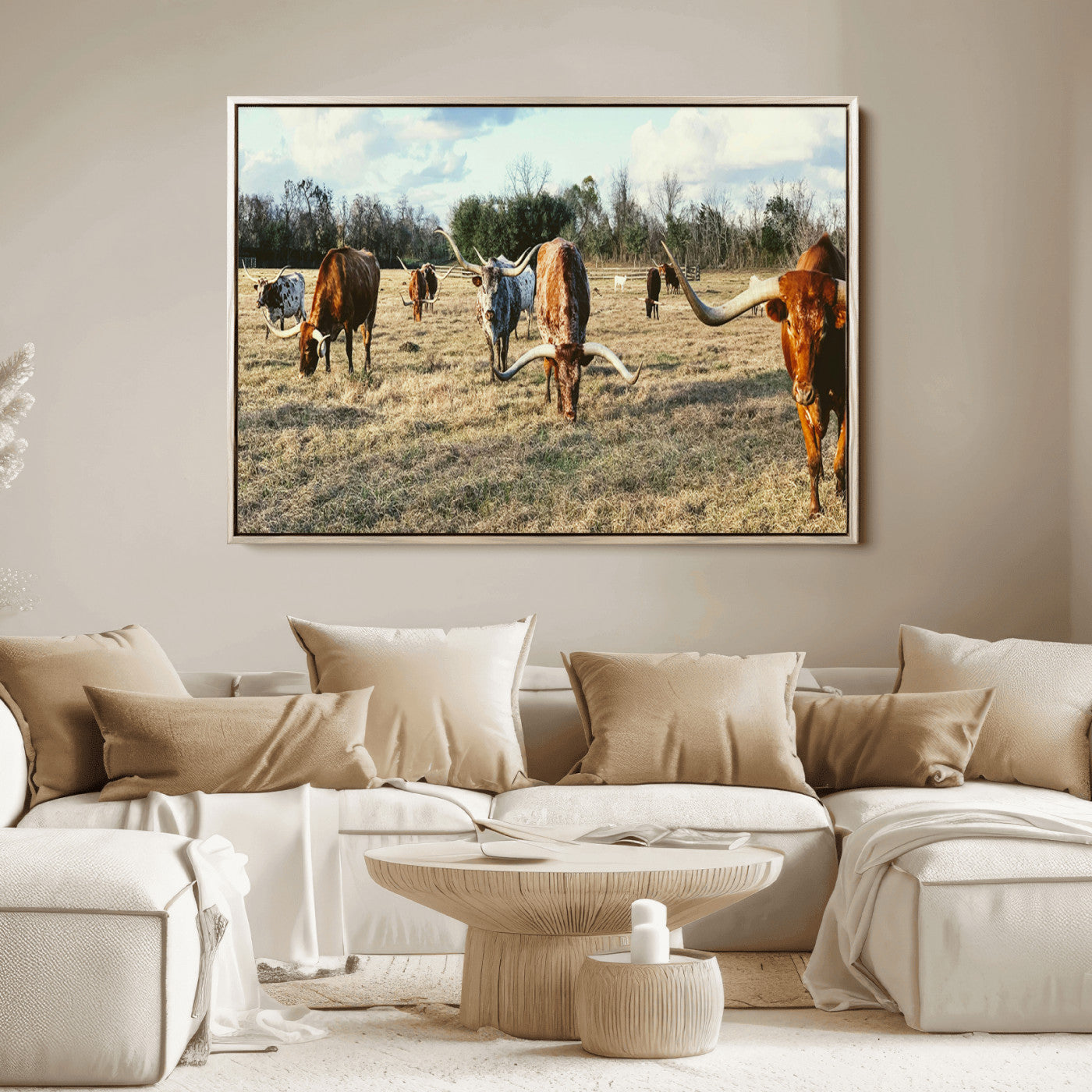 A herd of Texas Longhorn cattle grazing in an open field under a partly cloudy sky, capturing a rustic and Western ranch aesthetic.