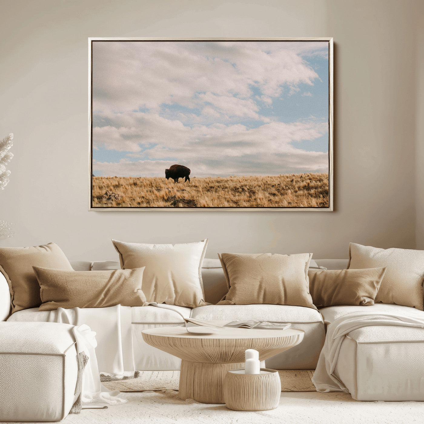 A solitary bison walking across a golden prairie under a vast, cloud-filled sky, evoking a peaceful, rustic western landscape for home decor.
