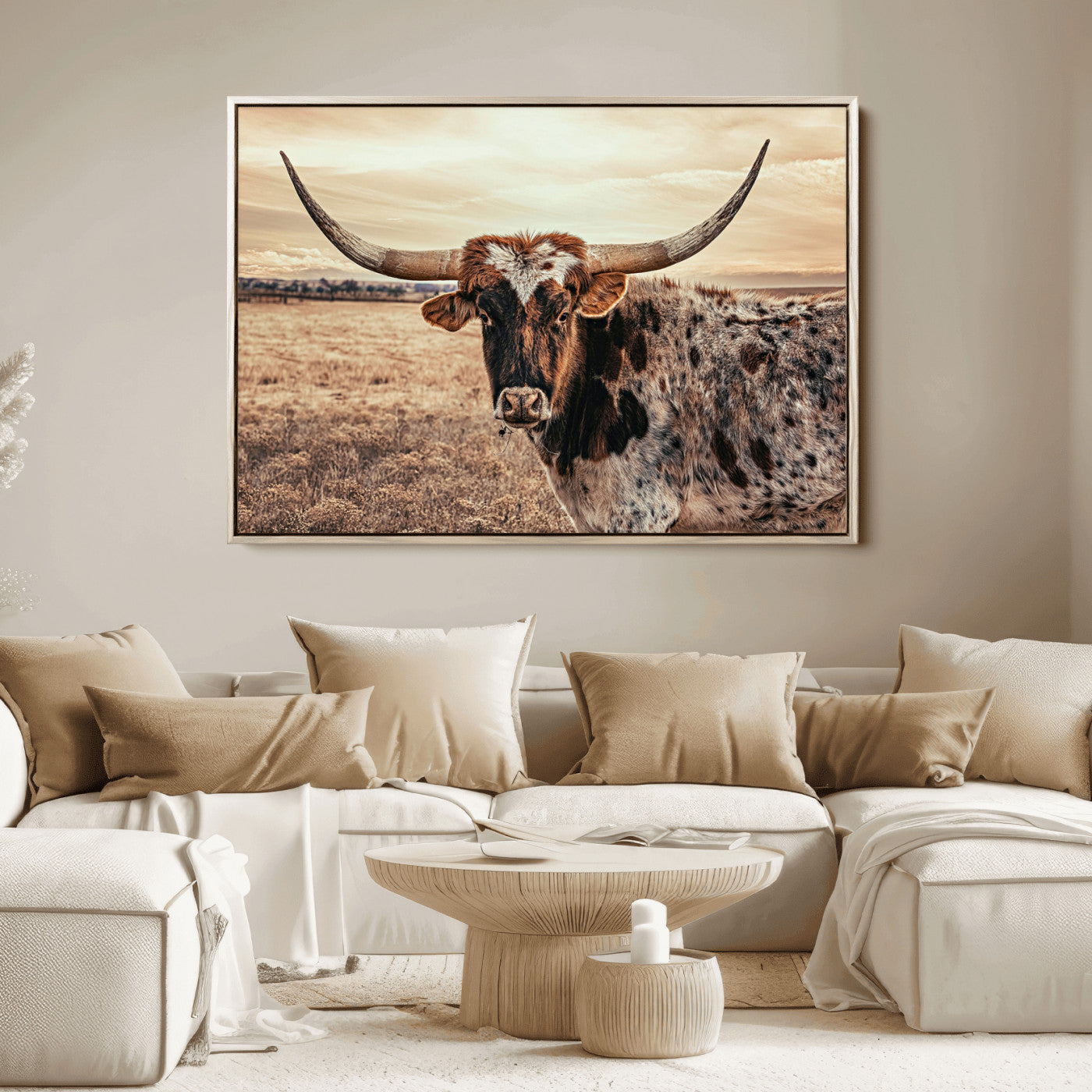 Close-up of a longhorn cow with distinctive curved horns standing in a dry grass field under a cloudy sky.