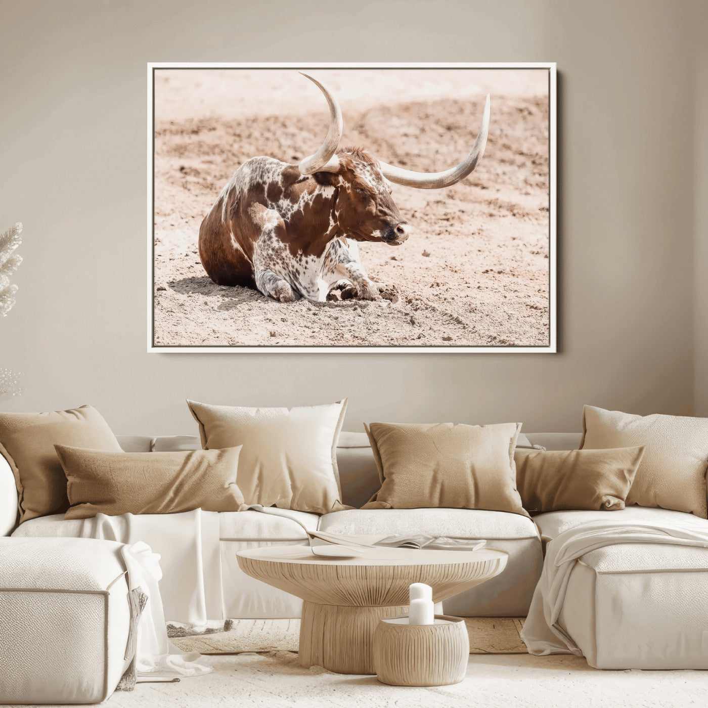 Texas Longhorn bull resting on dusty ground with warm tones, ideal for rustic western or farmhouse-themed wall decor.