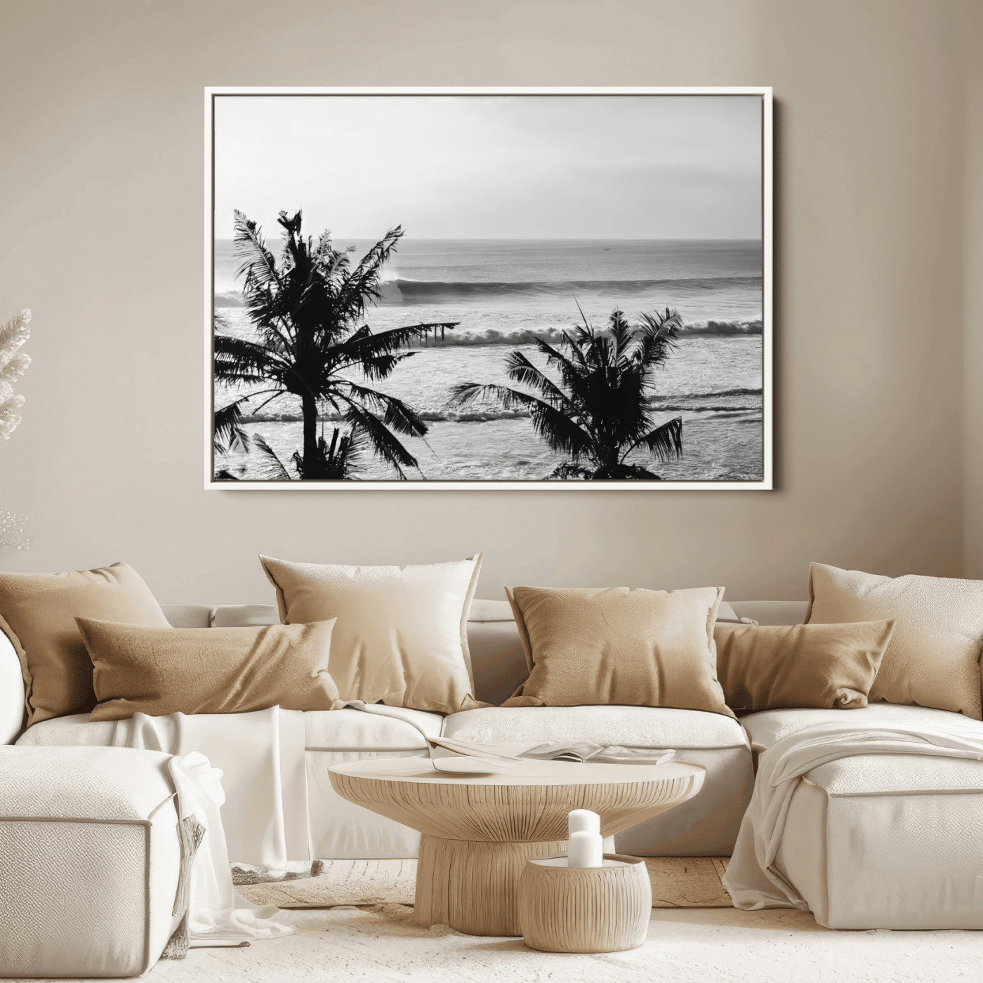 Black and white view of ocean waves crashing on a tropical coastline, framed by silhouetted palm trees under a vast, open sky.
