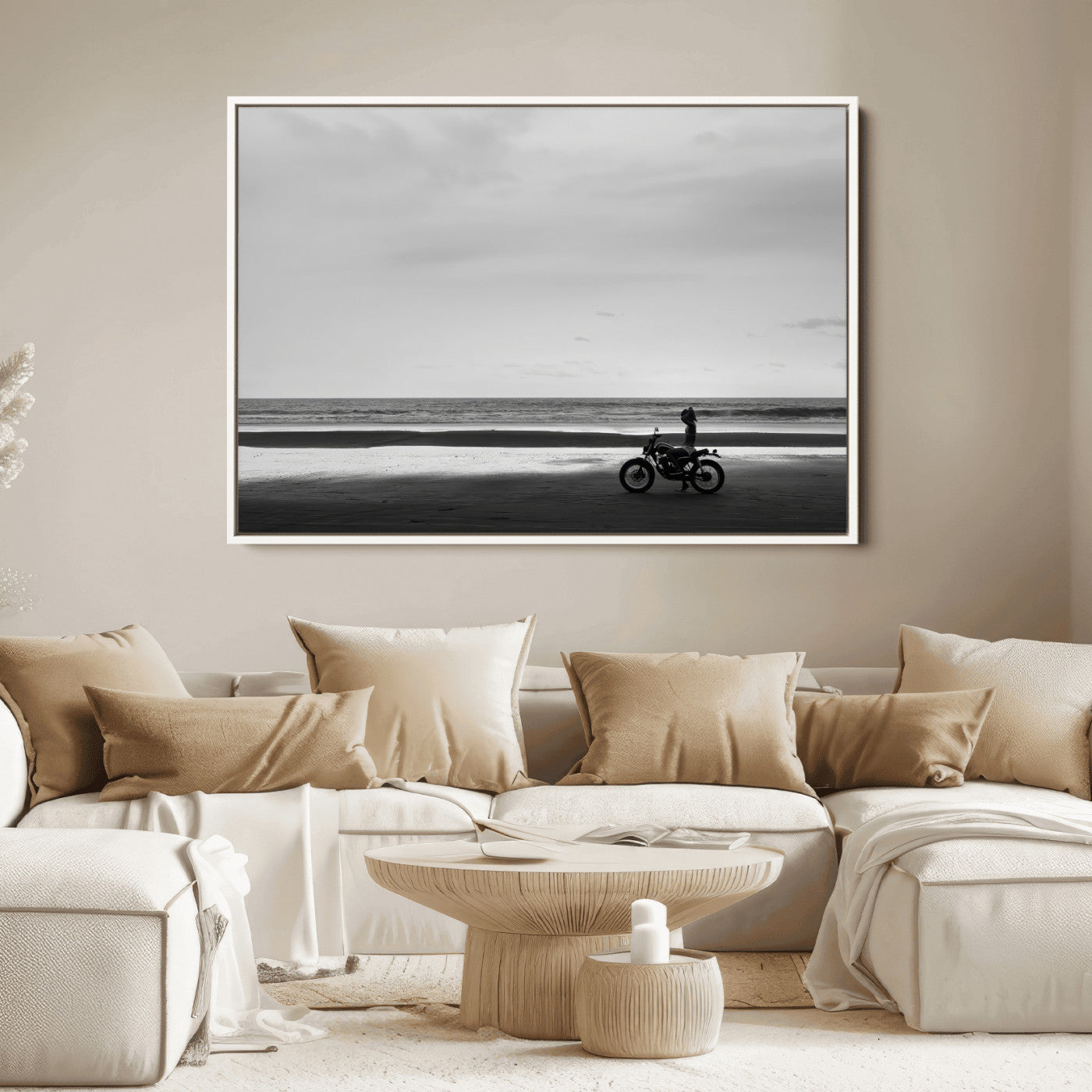 A motorcyclist on a vast beach, gazing at the ocean, capturing a moody and tranquil coastal adventure in black and white.
