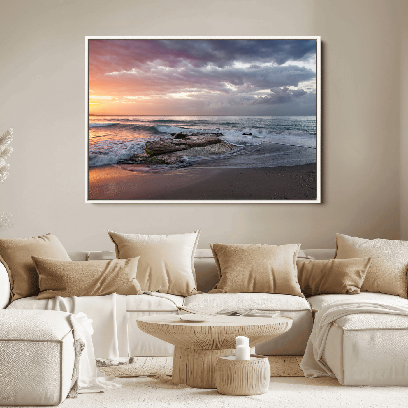 Dramatic sunset over a rocky shoreline with ocean waves gently reaching the sandy beach, creating a serene and coastal atmosphere.