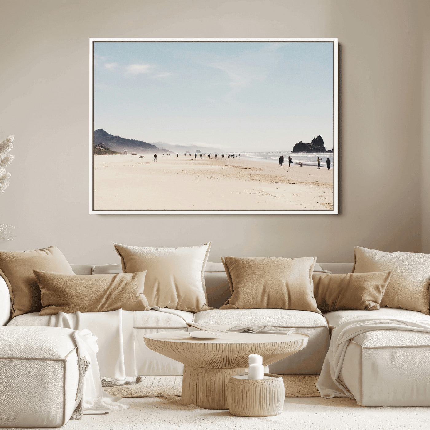 A serene beach with soft sand, misty mountains, and scattered people walking along the shoreline, creating a peaceful coastal landscape.