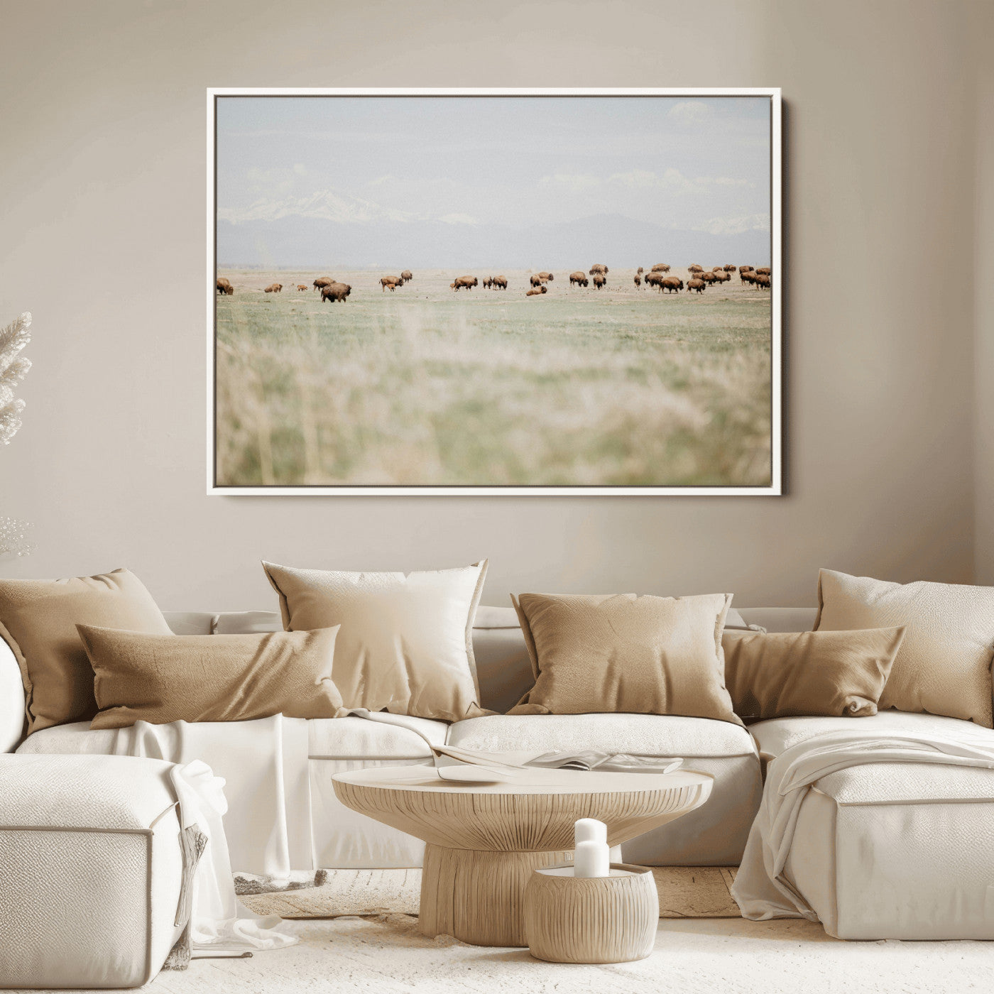 A herd of bison grazing in an open prairie with distant mountains under a soft sky, creating a serene and rustic Western landscape.