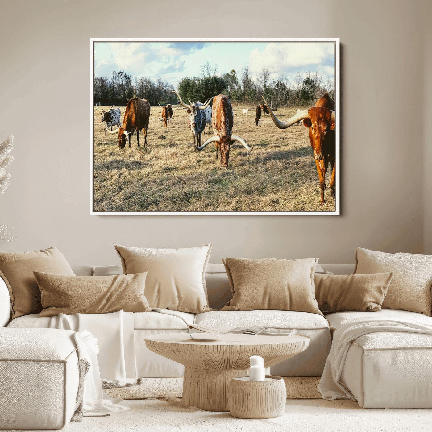 A herd of Texas Longhorn cattle grazing in an open field under a partly cloudy sky, capturing a rustic and Western ranch aesthetic.