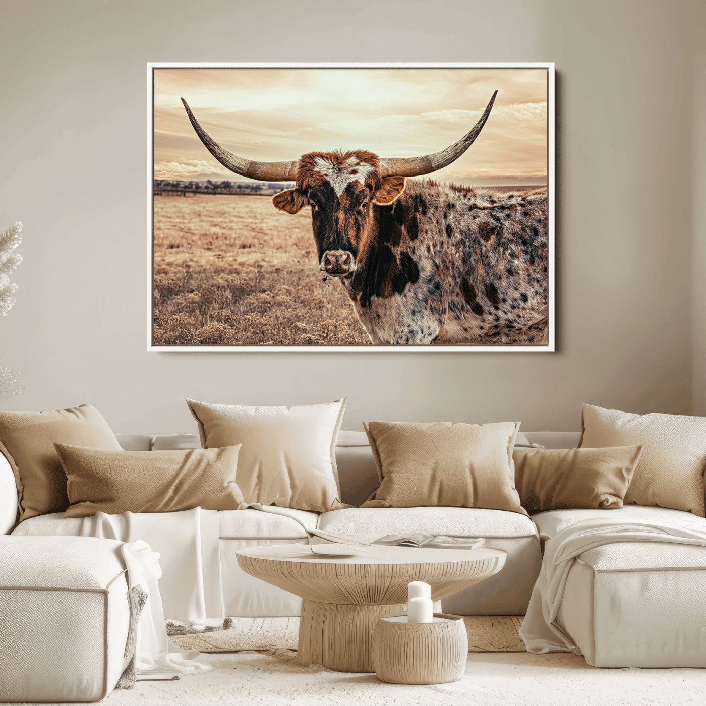 Close-up of a longhorn cow with distinctive curved horns standing in a dry grass field under a cloudy sky.