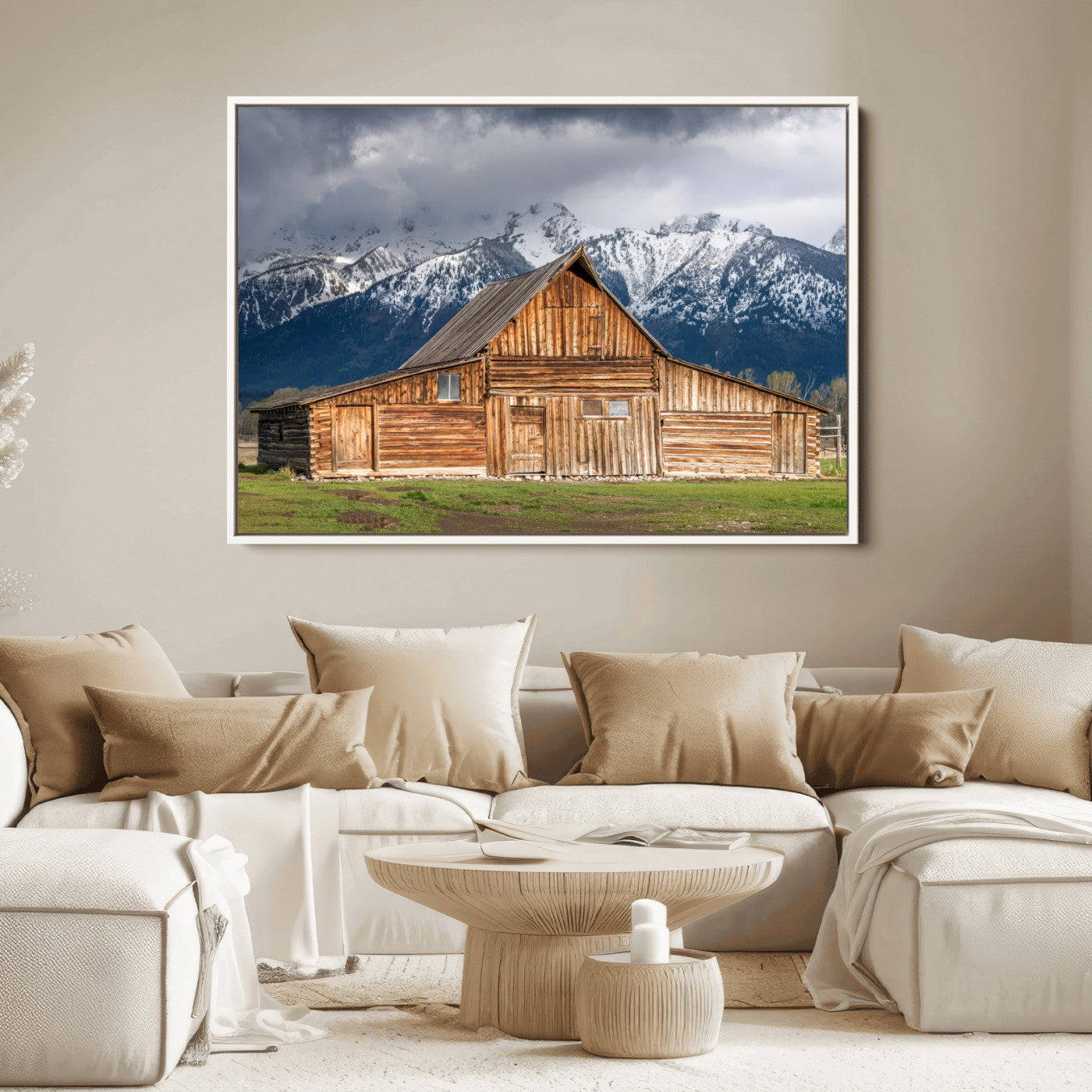 A stunning wall art canvas print featuring a rustic wooden barn set against a backdrop of snow-capped mountains under a dramatic cloudy sky, perfect for adding a touch of rural charm to any space.
