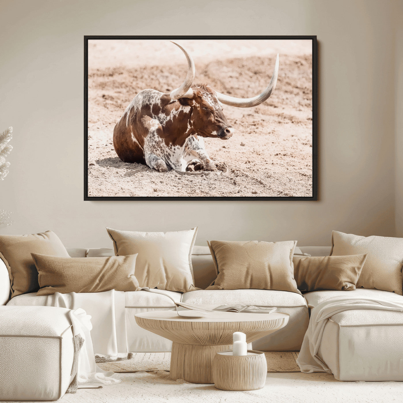 Texas Longhorn bull resting on dusty ground with warm tones, ideal for rustic western or farmhouse-themed wall decor.