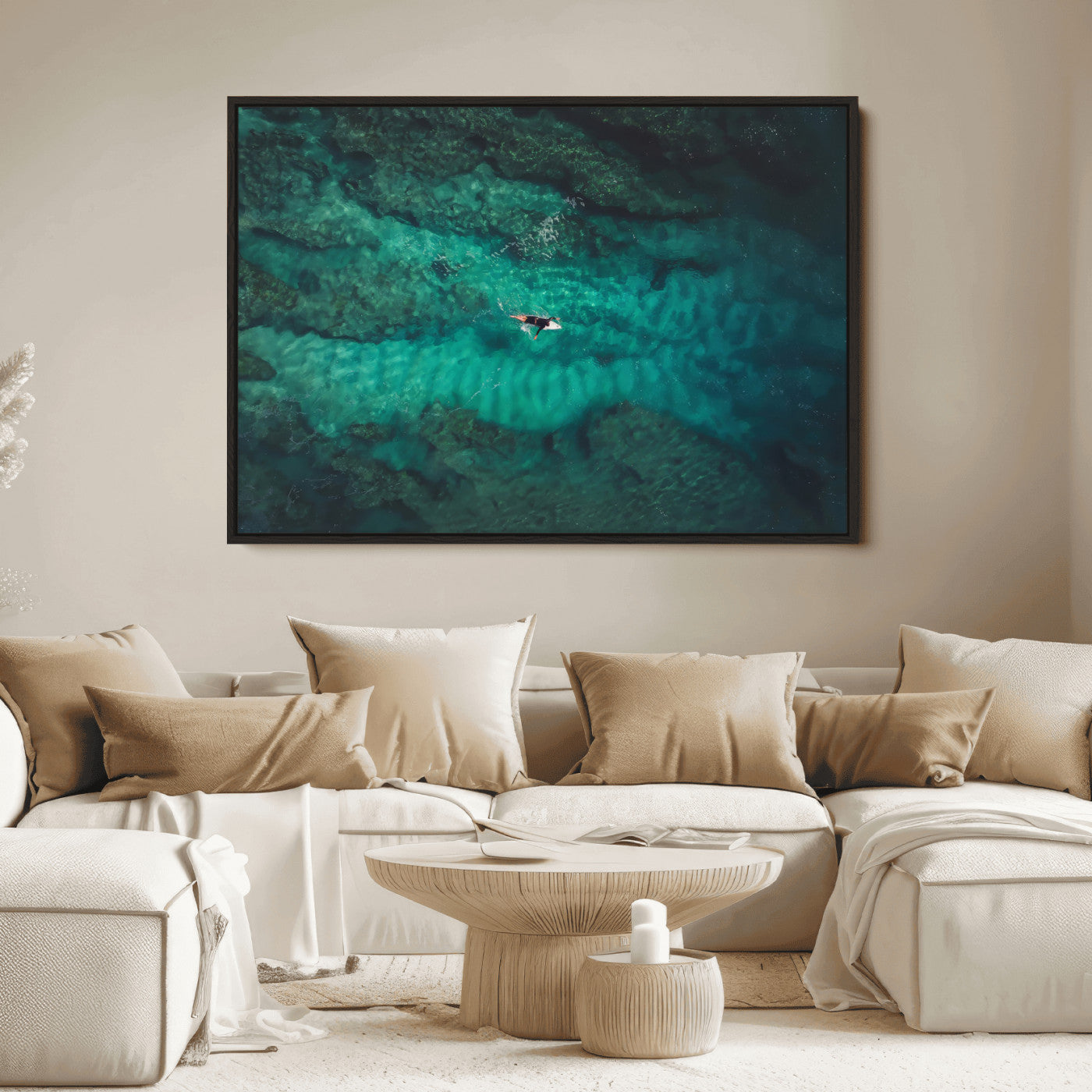 An aerial view of a solo surfer paddling through crystal-clear turquoise waters over a sunlit reef, capturing the beauty and serenity of open water surfing.