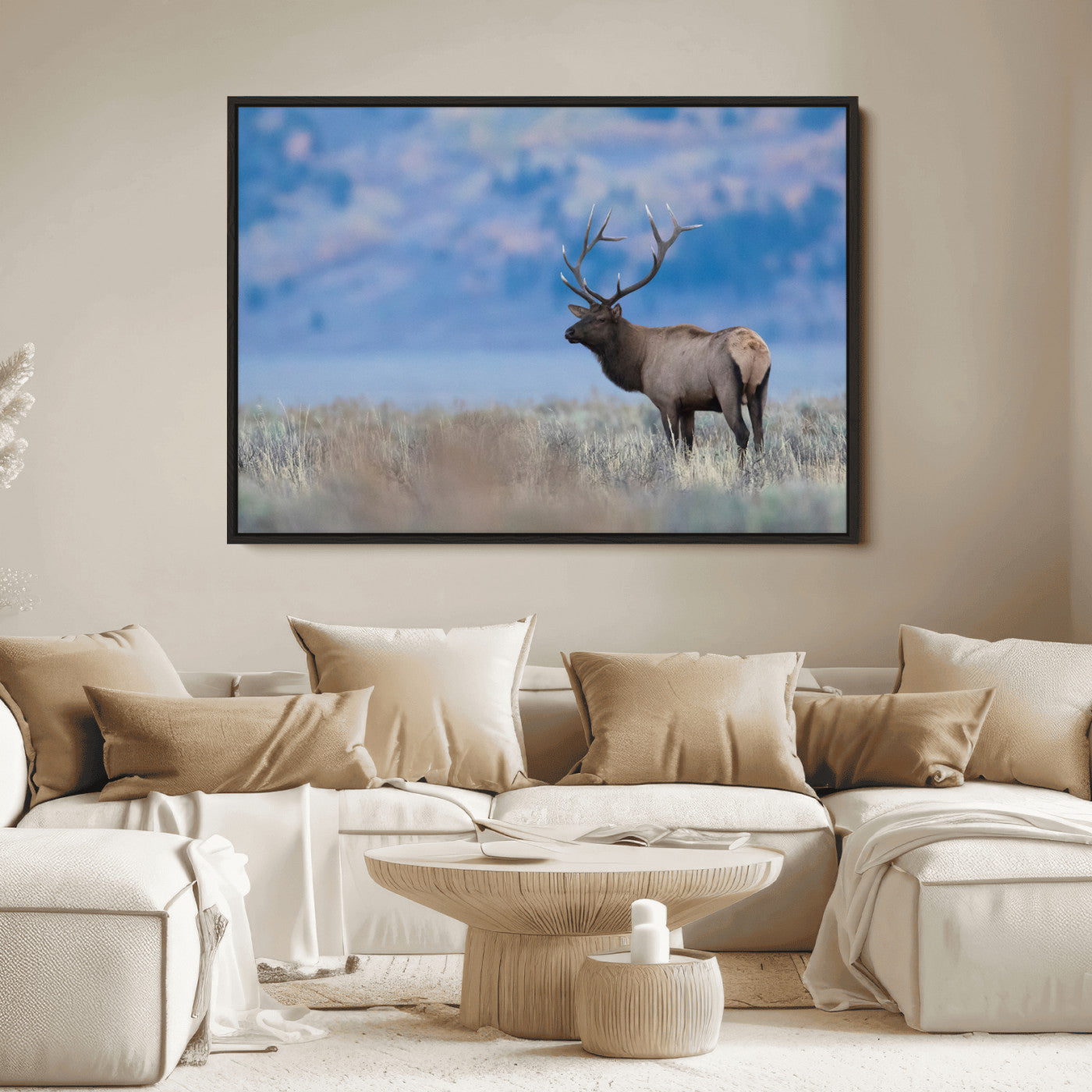Elk with large antlers standing in open field, mountains blurred in background, perfect for rustic cabin or lodge-style decor.