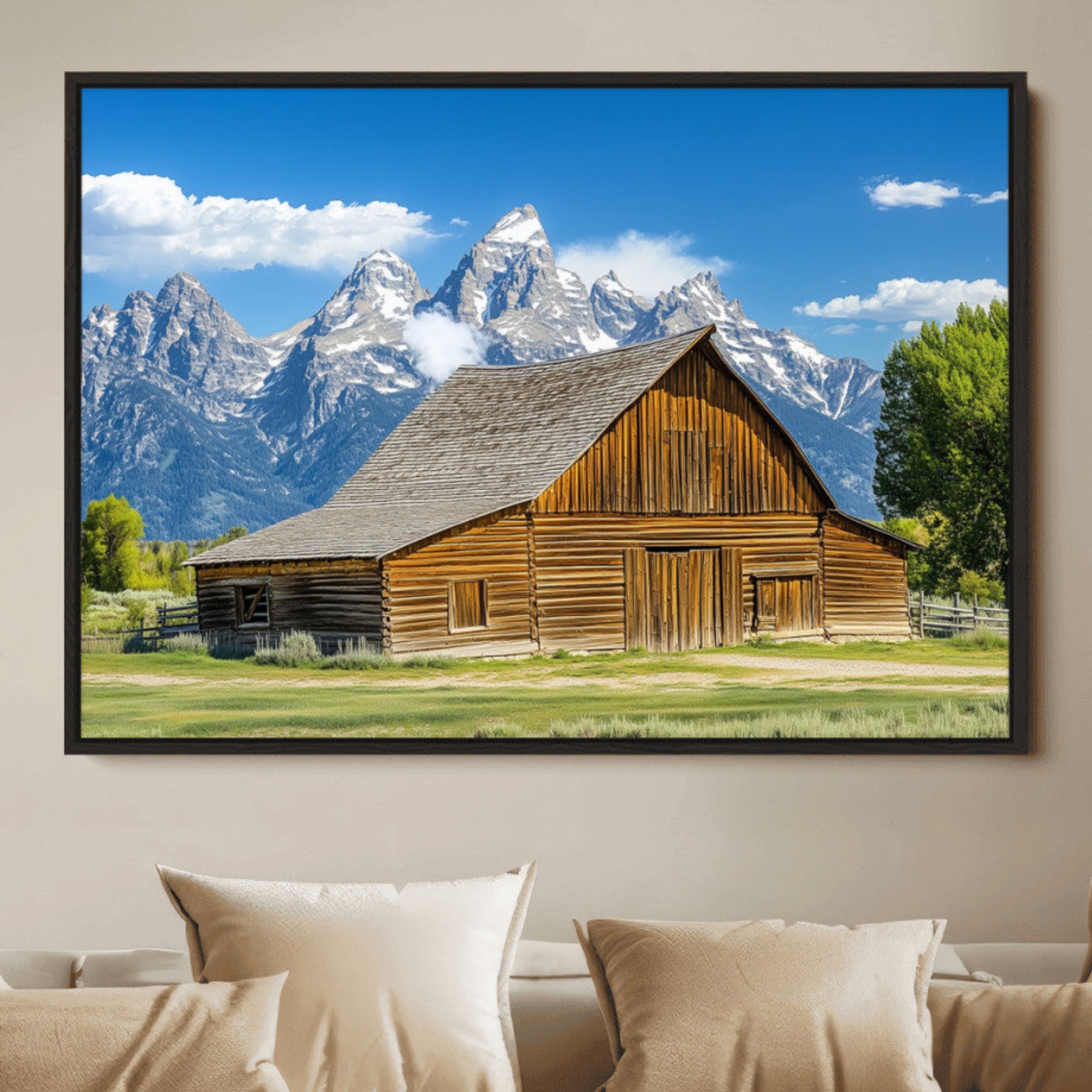 A rustic wooden barn sits in front of towering mountain peaks under a clear blue sky, perfect for farmhouse or cabin style interiors.