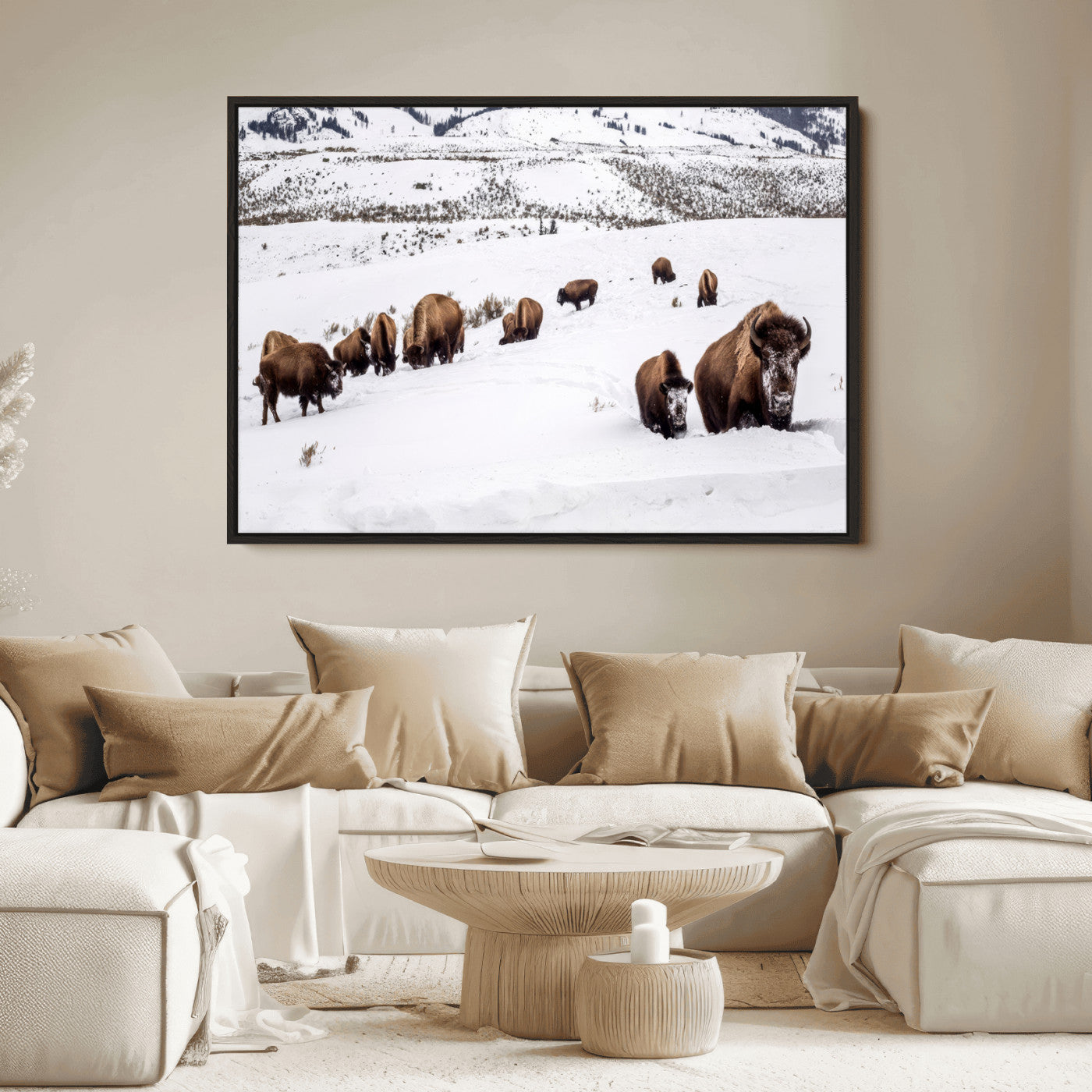 A herd of bison walking through deep snow in a mountain valley, perfect for rustic, cabin or western-themed wall decor.