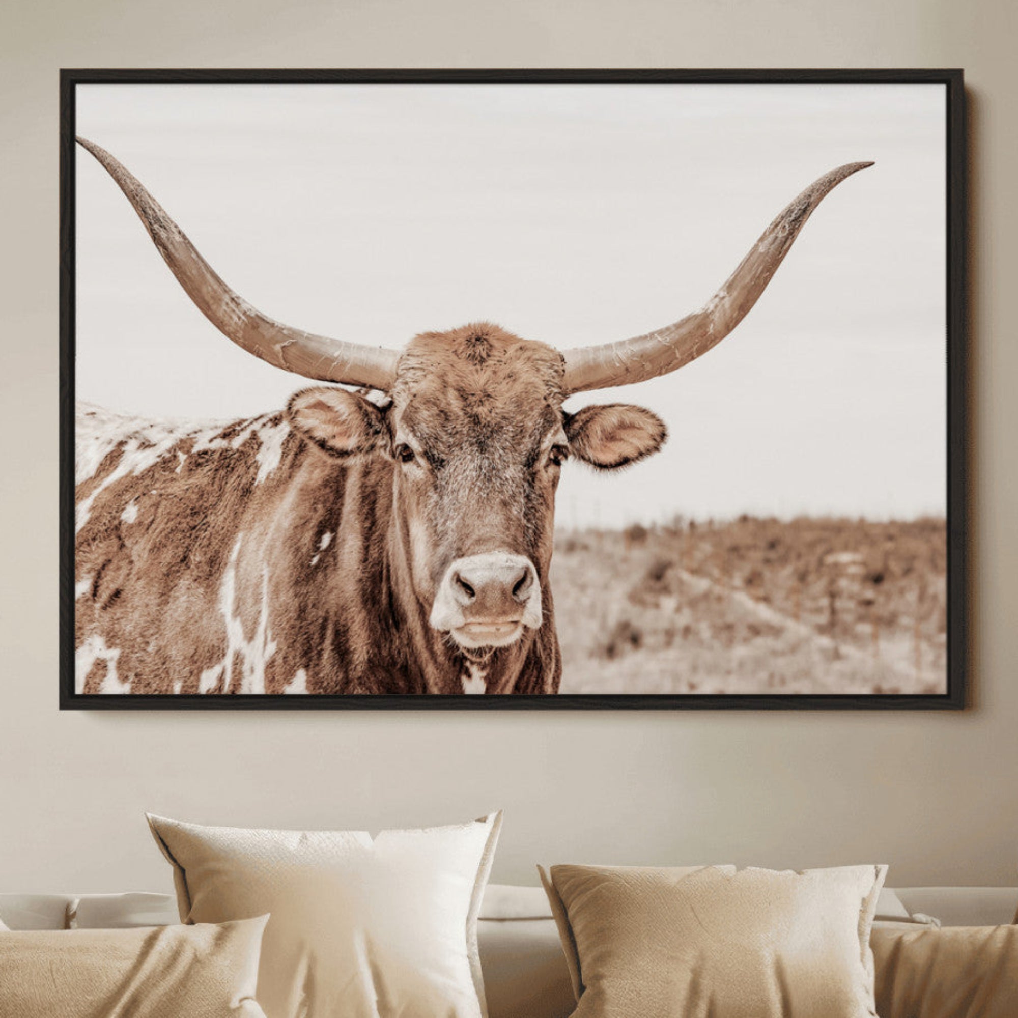 A longhorn cow in soft beige desert tones, standing calmly in open land, perfect for neutral western or rustic farmhouse interiors.