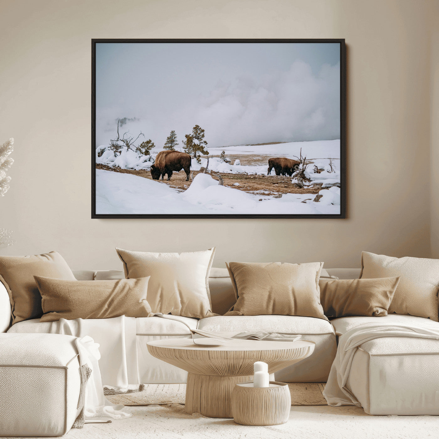 Two bison grazing in a snowy open landscape with misty hills in the background, creating a peaceful and rustic winter scene.
