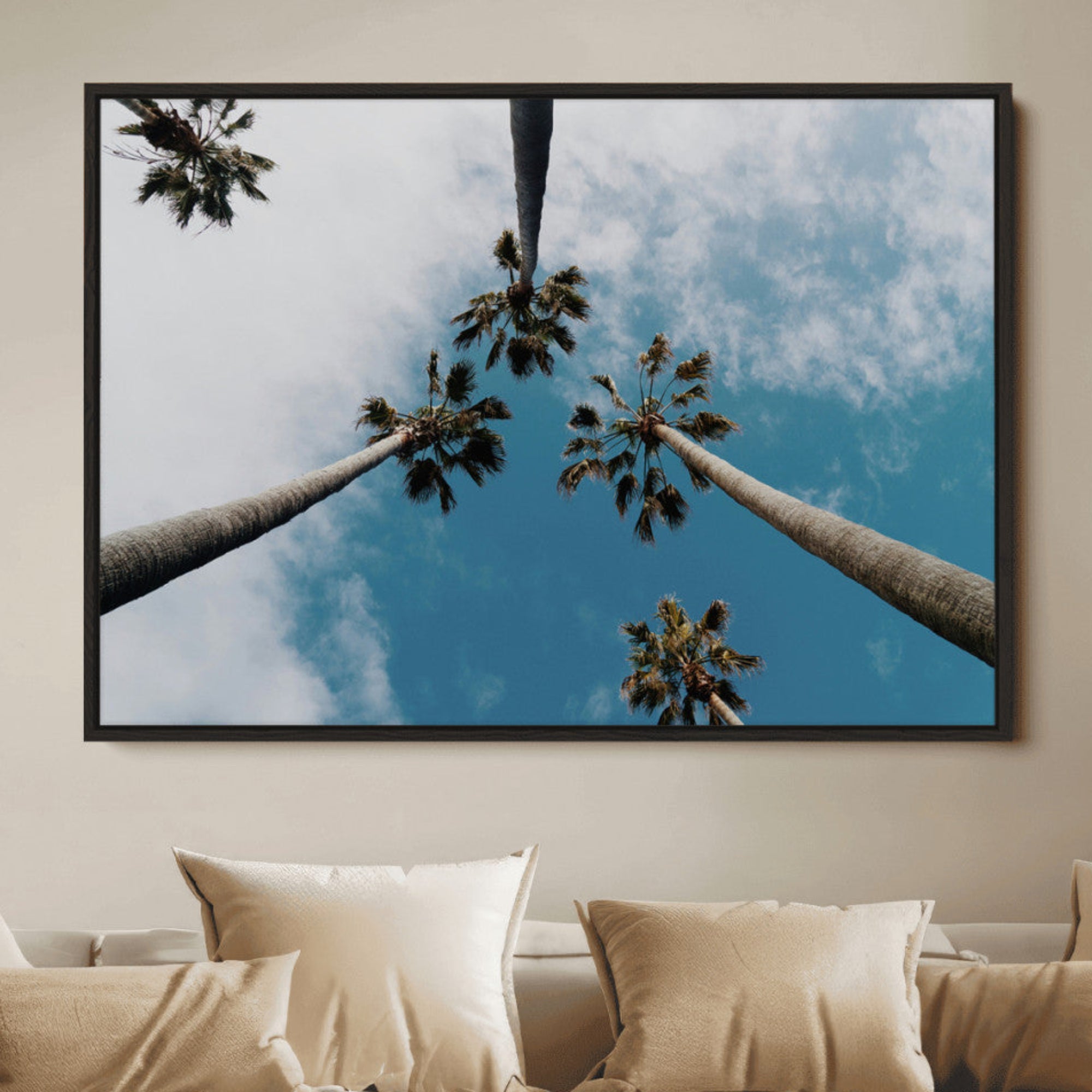 Looking up at tall palm trees against a bright blue sky with scattered clouds, creating a tropical and airy atmosphere for modern home decor.