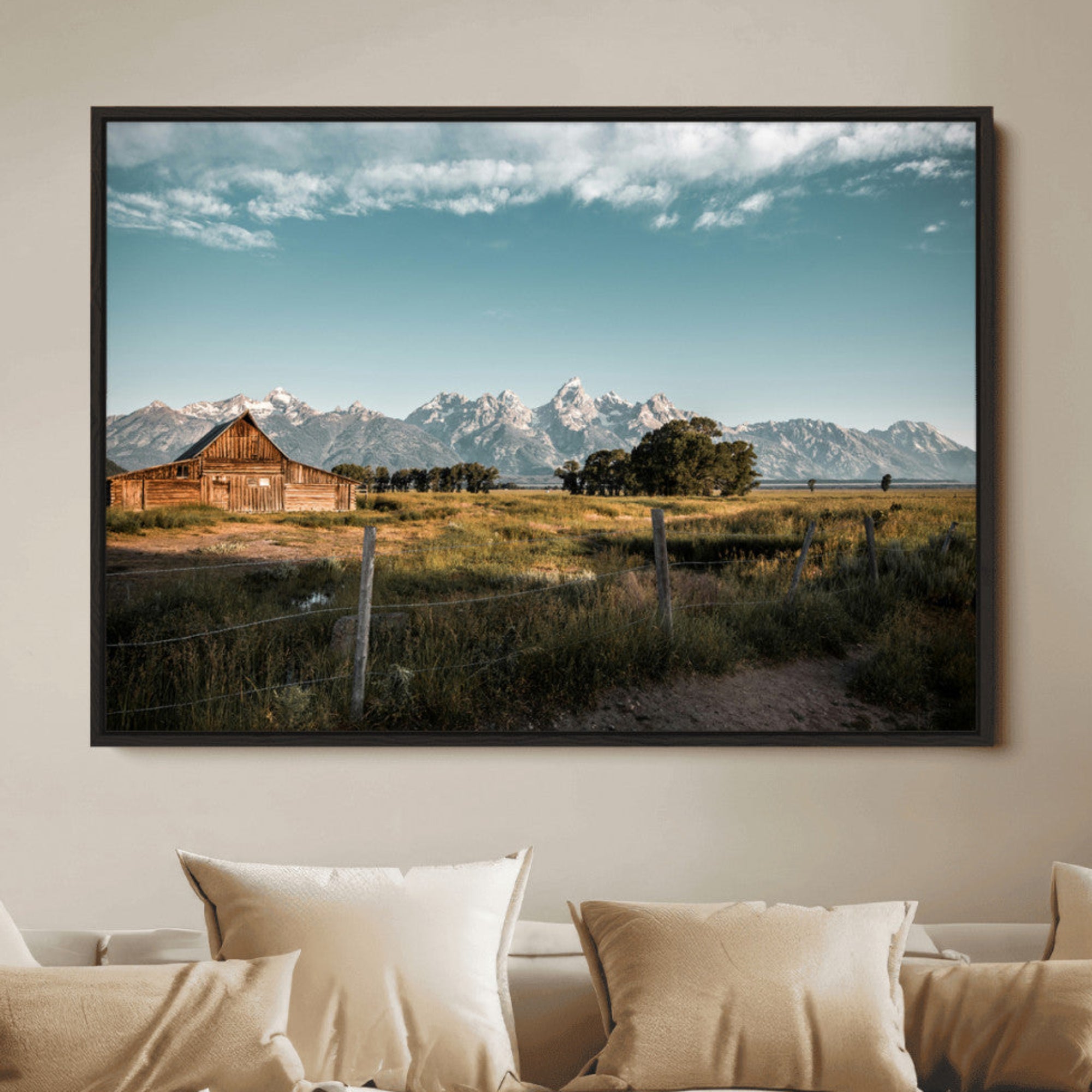 A rustic farmhouse with a wooden barn set against majestic mountain peaks under a soft blue sky, evoking peaceful countryside charm.