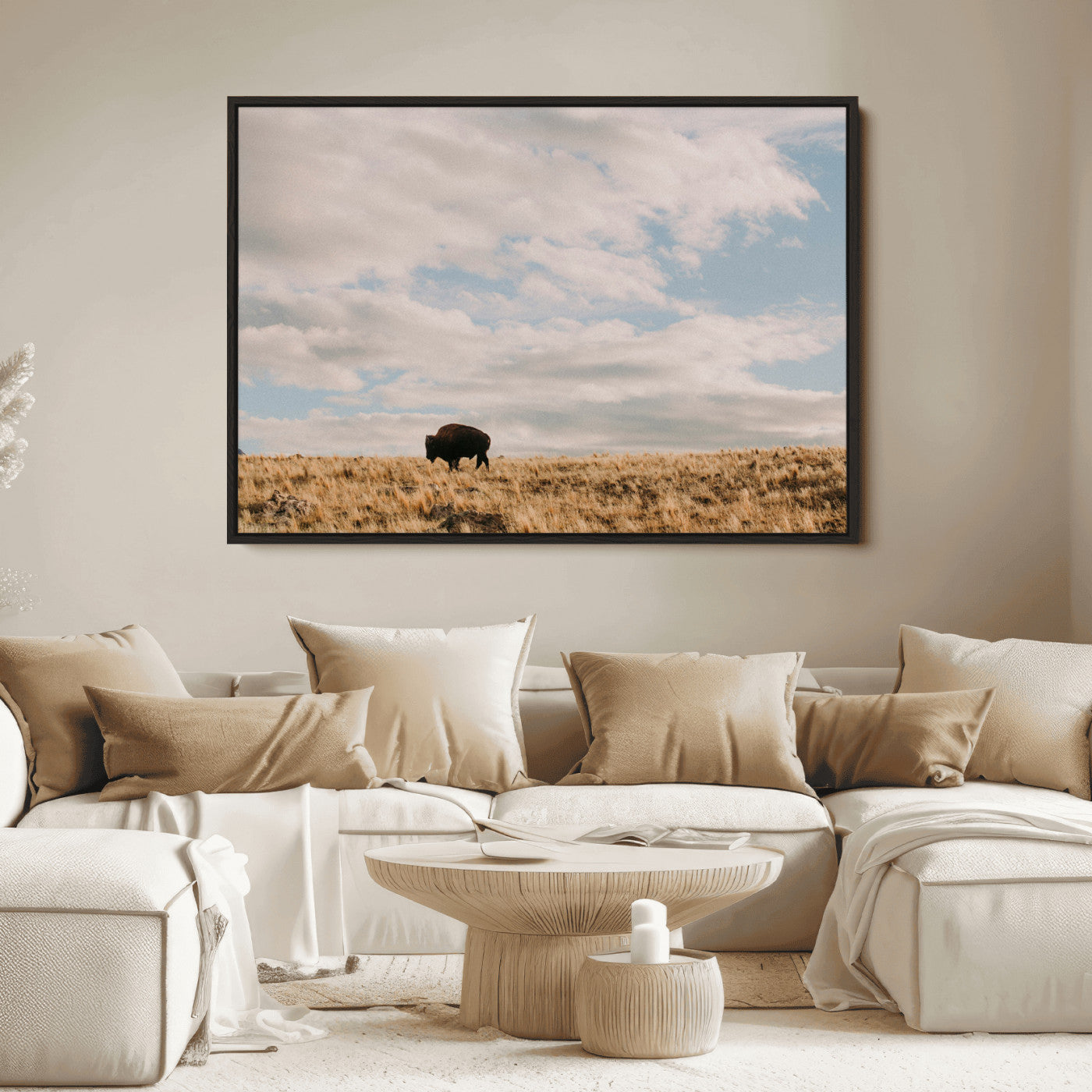 A solitary bison walking across a golden prairie under a vast, cloud-filled sky, evoking a peaceful, rustic western landscape for home decor.