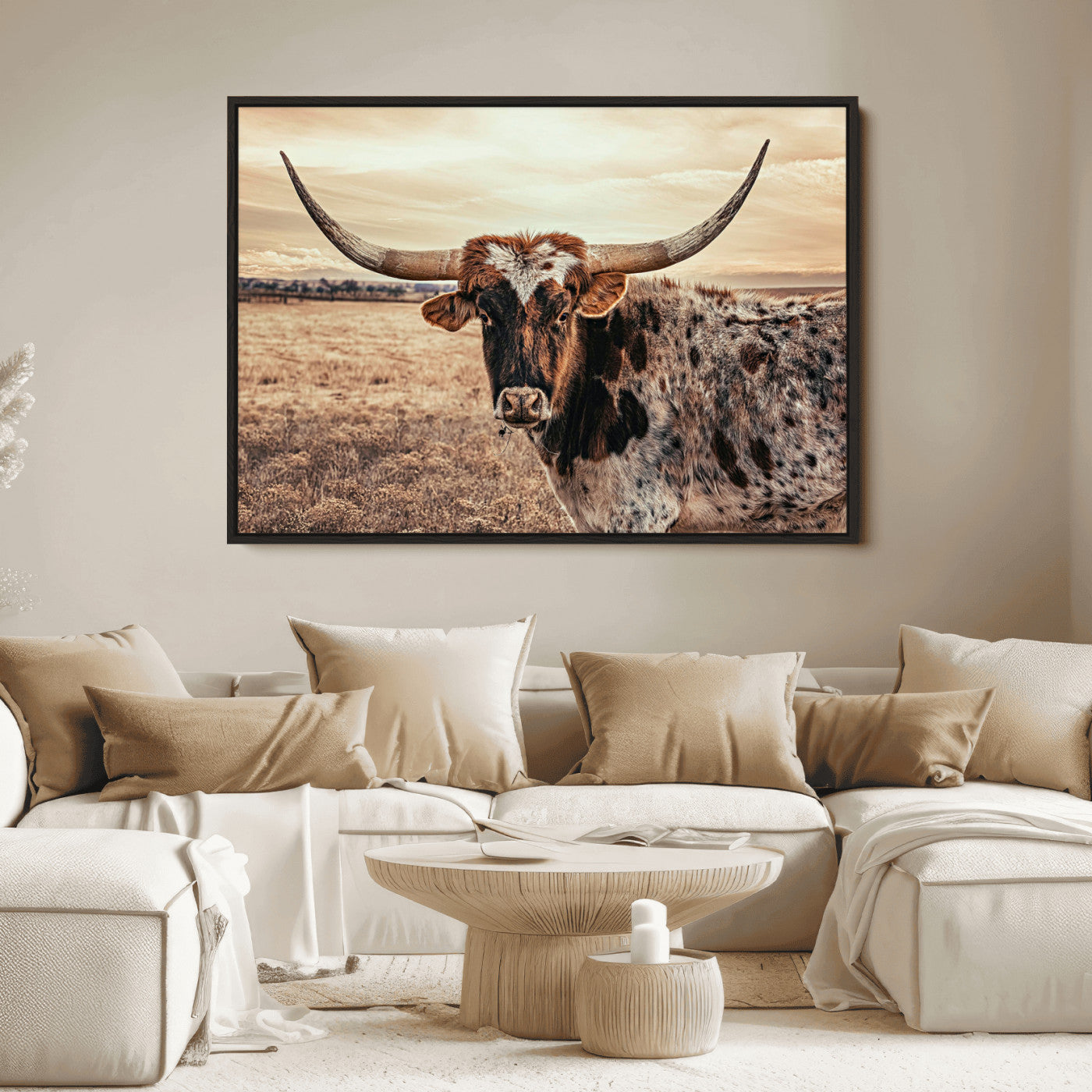 Close-up of a longhorn cow with distinctive curved horns standing in a dry grass field under a cloudy sky.